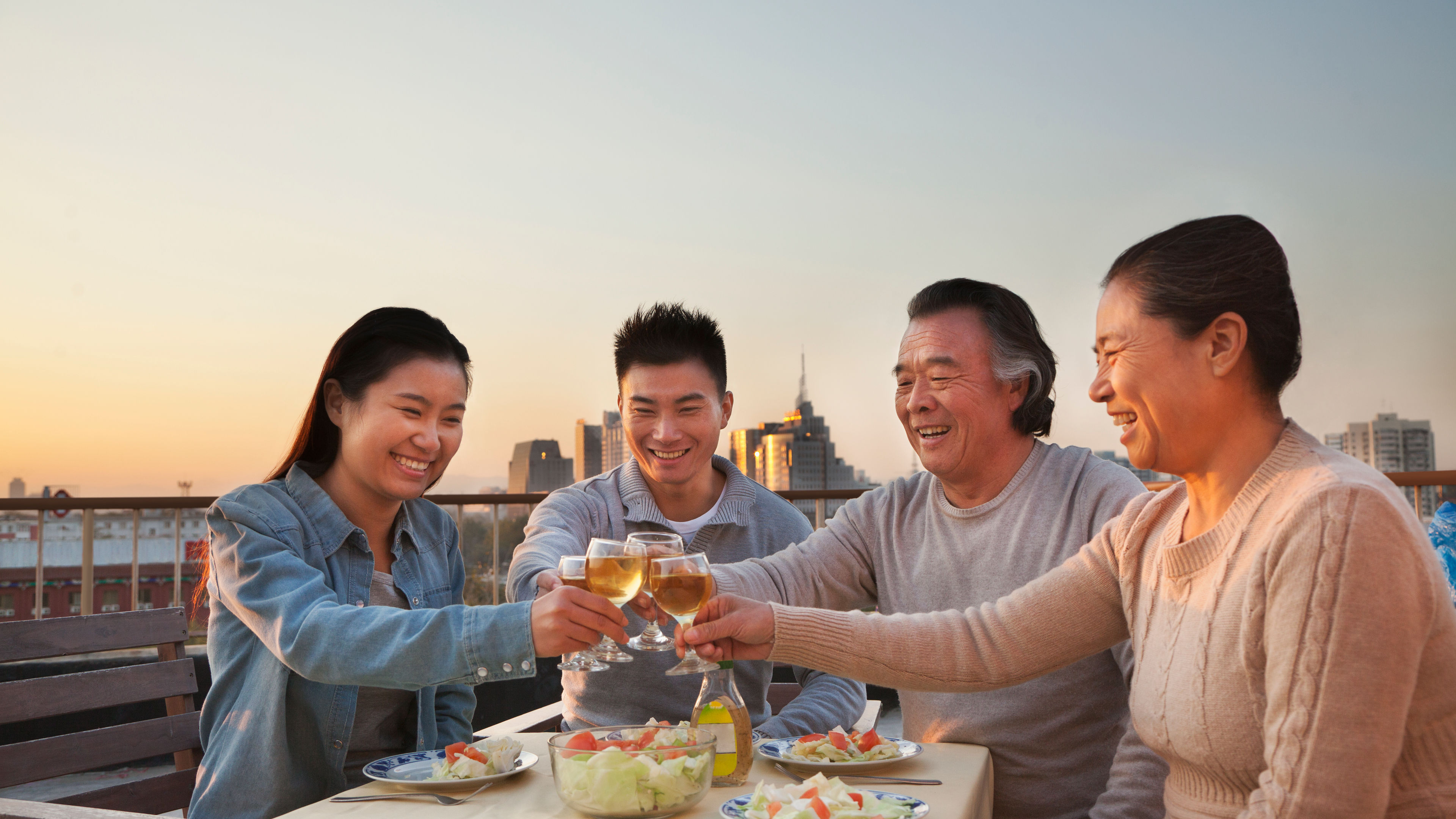 A family of four enjoying their tasty food and variety of drinks 