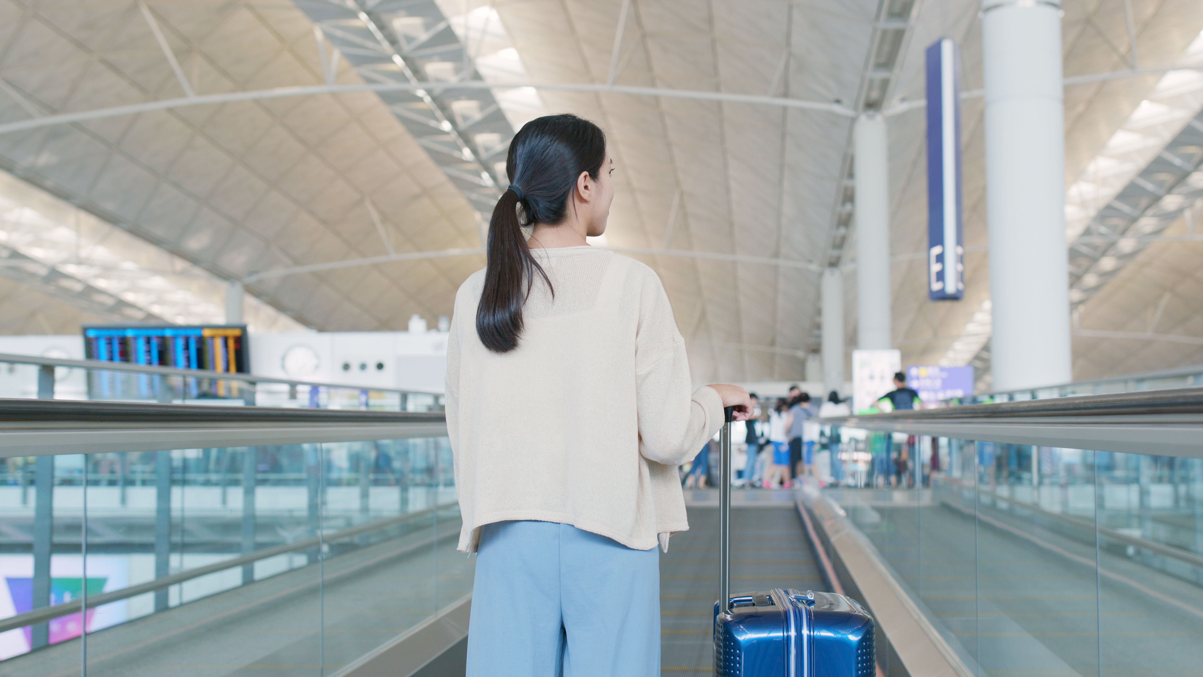 A woman with a luggage in hand in the airport 