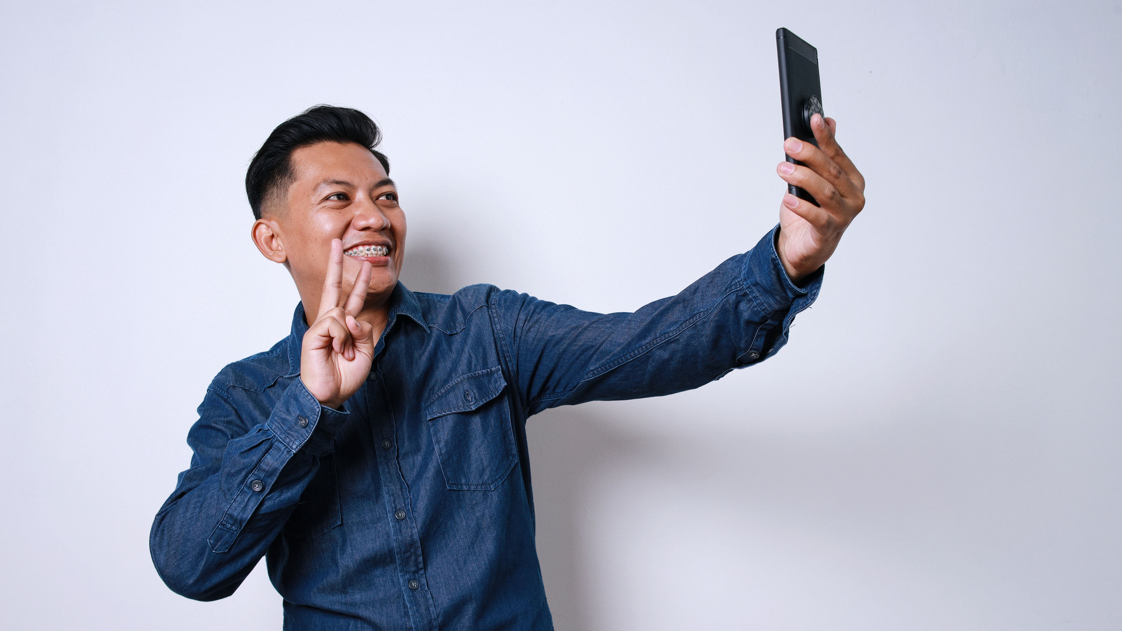 Asian Adult Man With Braces Teeth Selfie Using Smartphone  