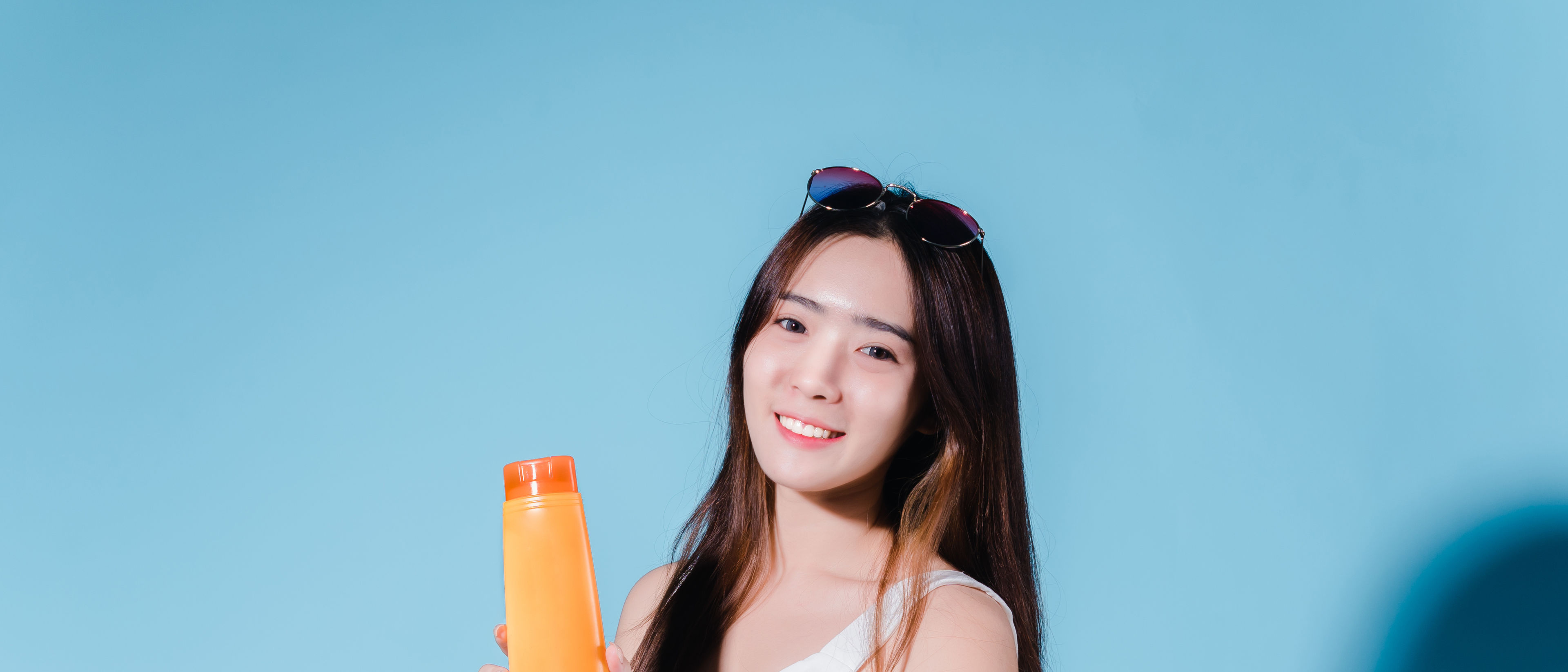 Charming woman holding sunscreen