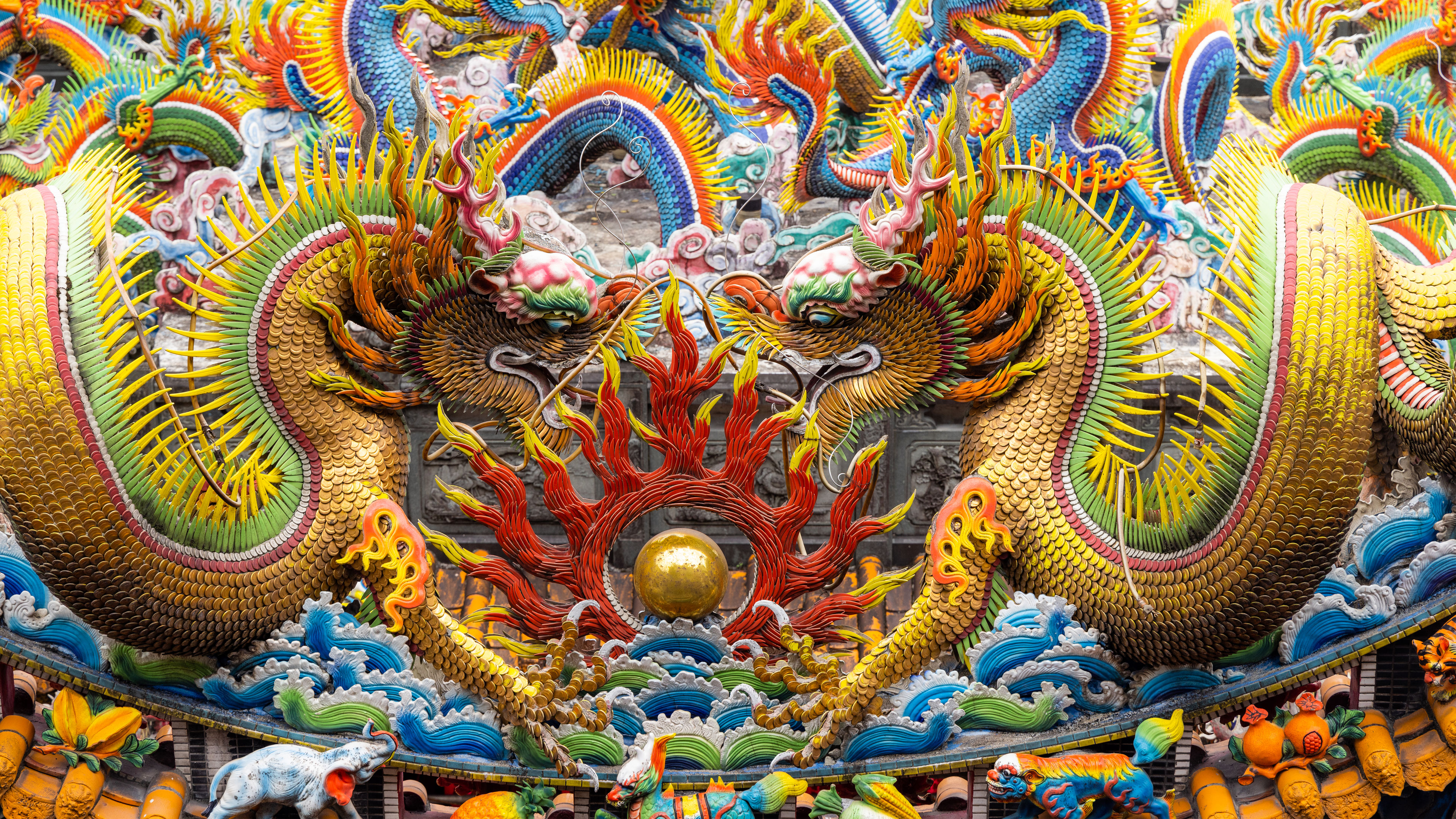 Vibrant dragon sculptures adorn the rooftop of a Chinese temple 