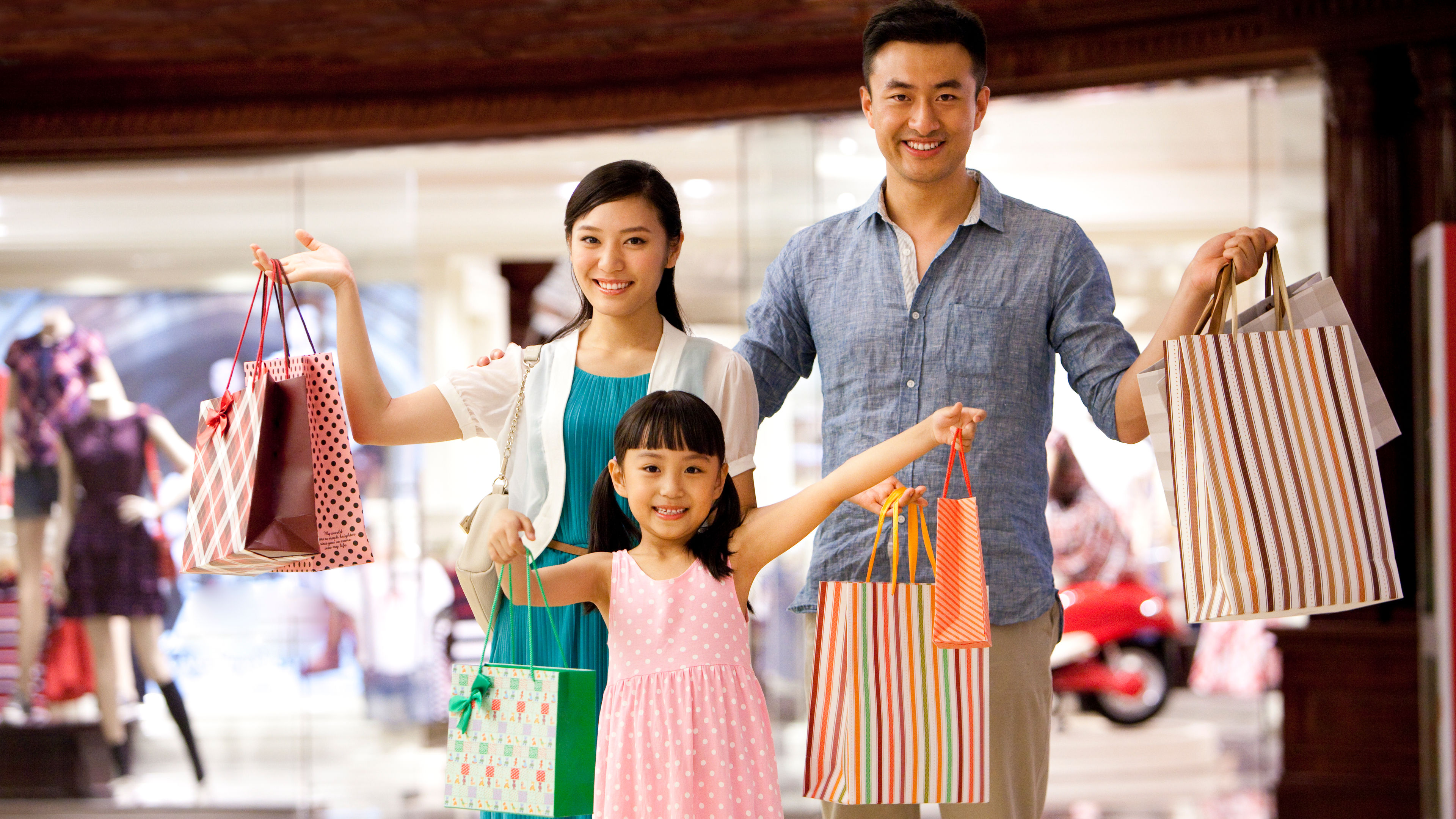 A cheerful family poses with colorful shopping bags after a joyful day at a department store 