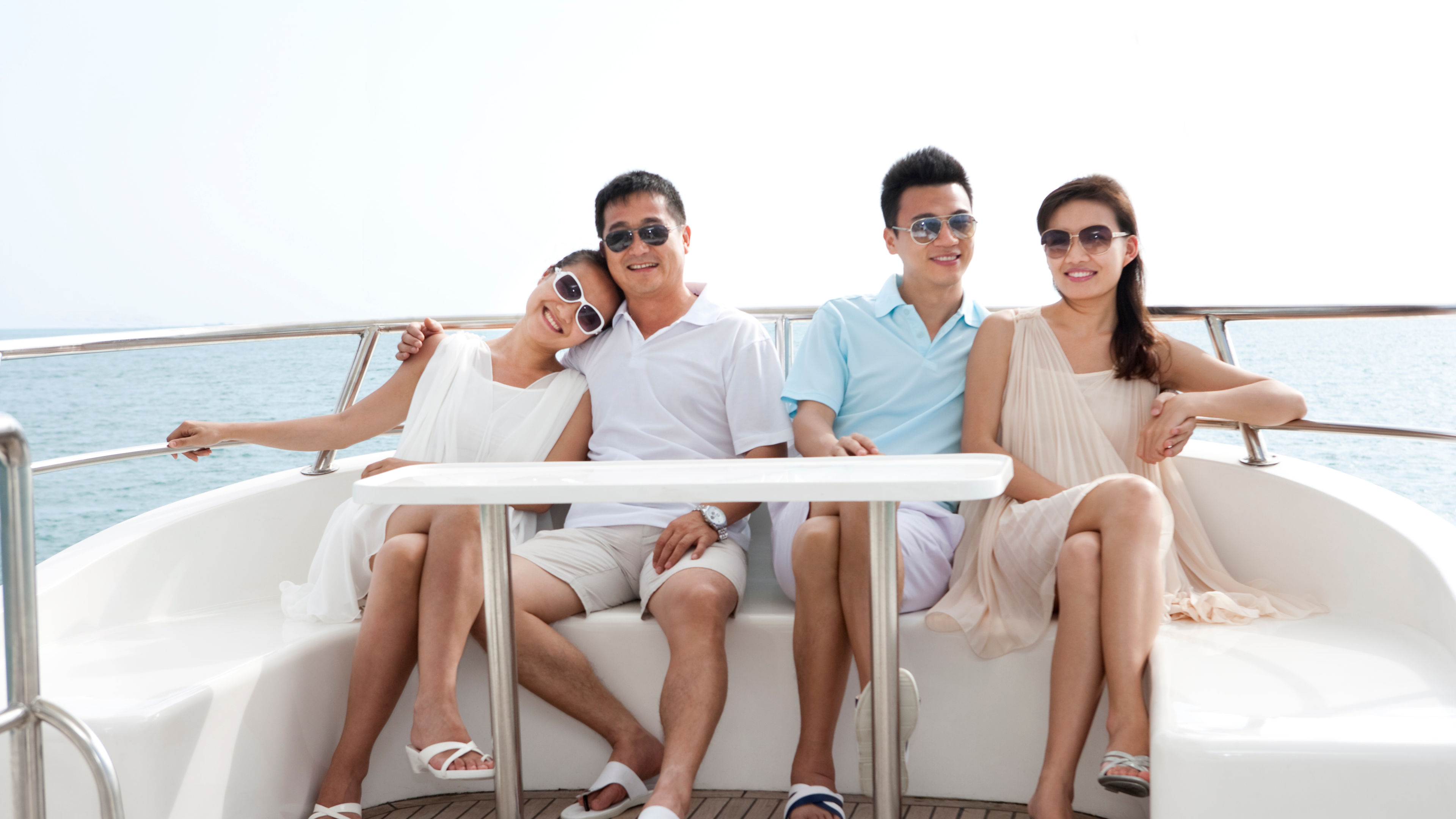 A group of friends lounges on a yacht, soaking up the sun, enjoying the ocean breeze 