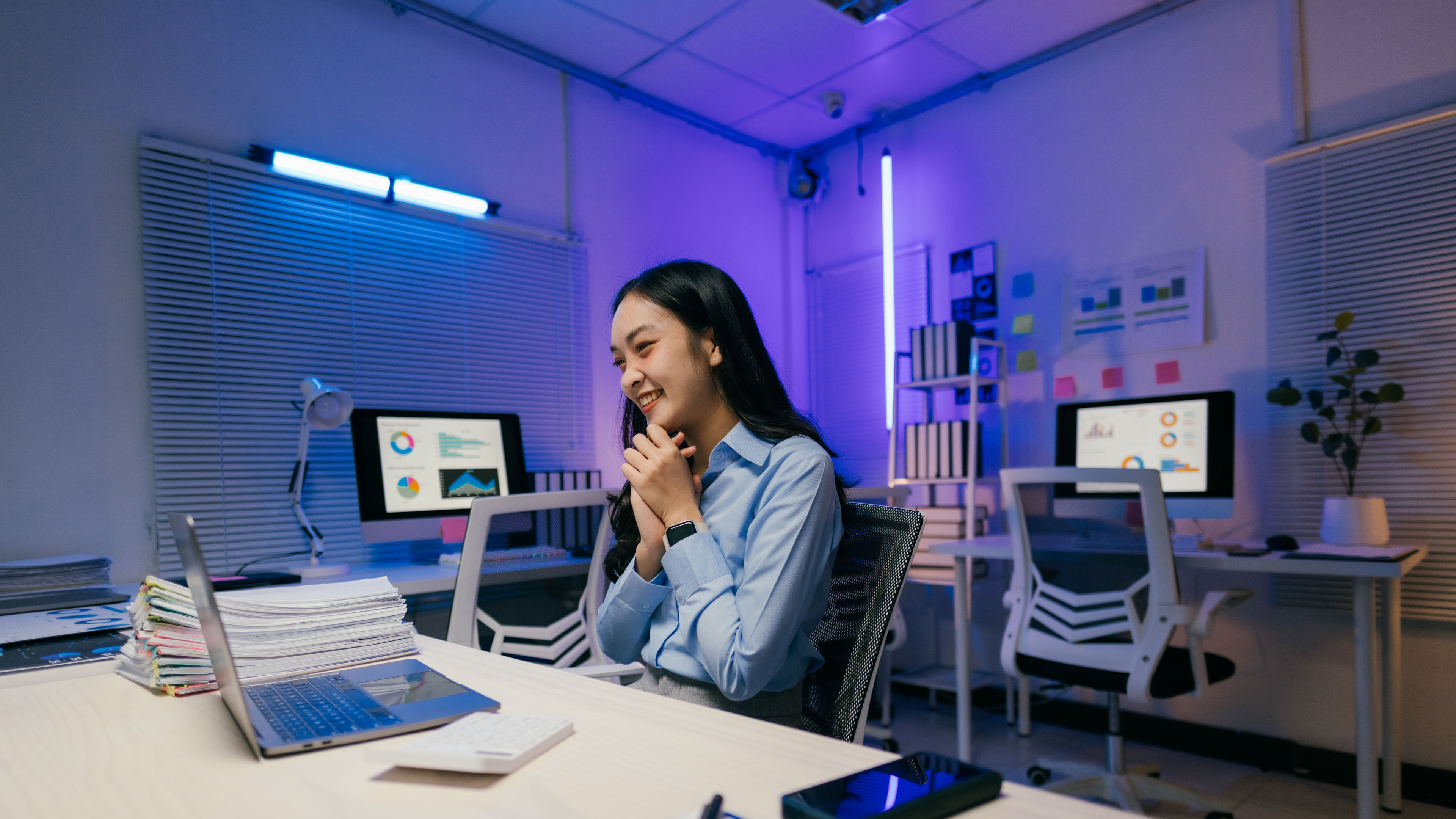 Happy young asian businesswoman looking at laptop and celebrating success, working late at night.