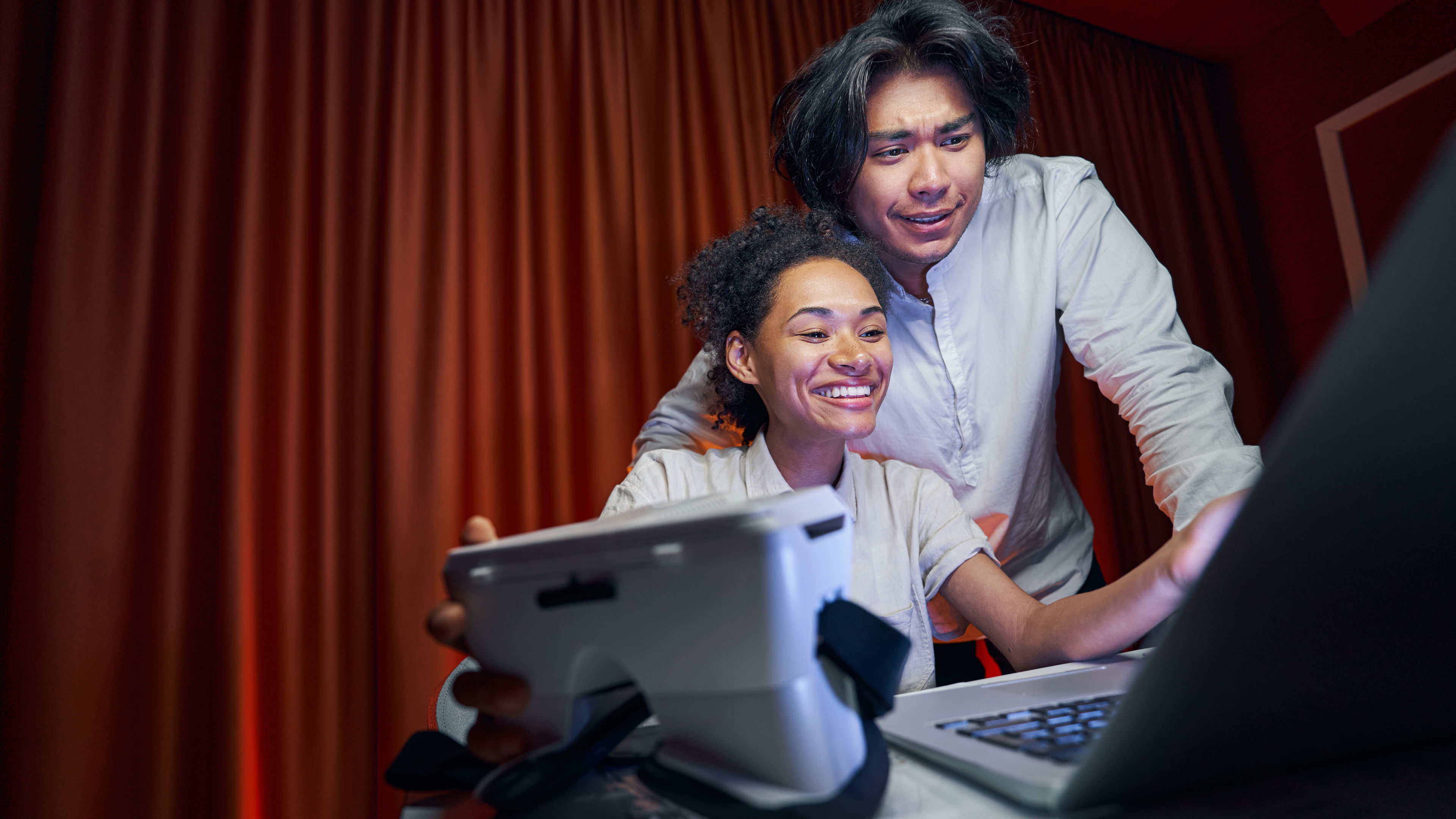 A male and a female person preparing for a meeting, organising their materials and getting ready to discuss. 