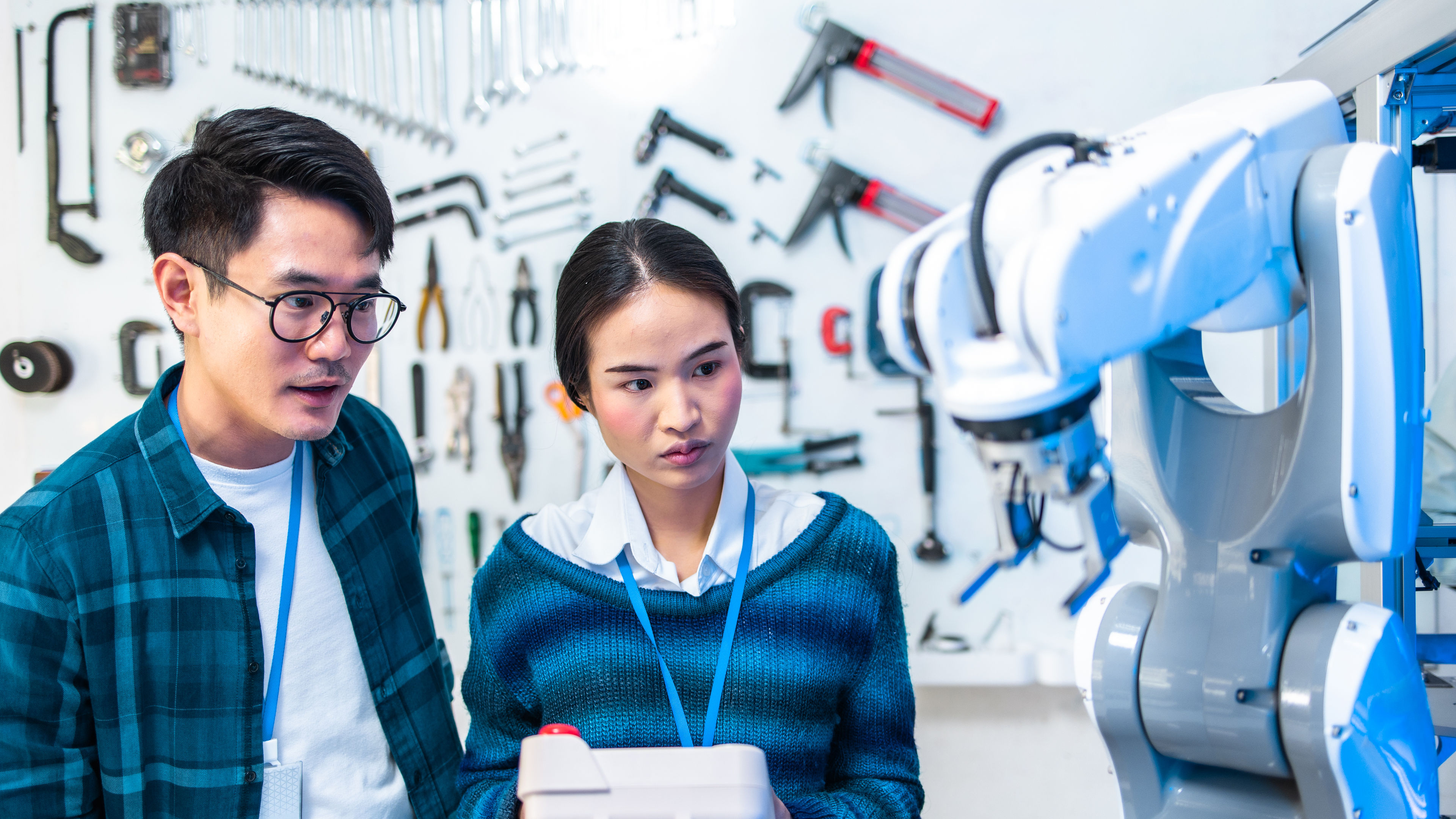 Asian man and woman next to a tech gadget