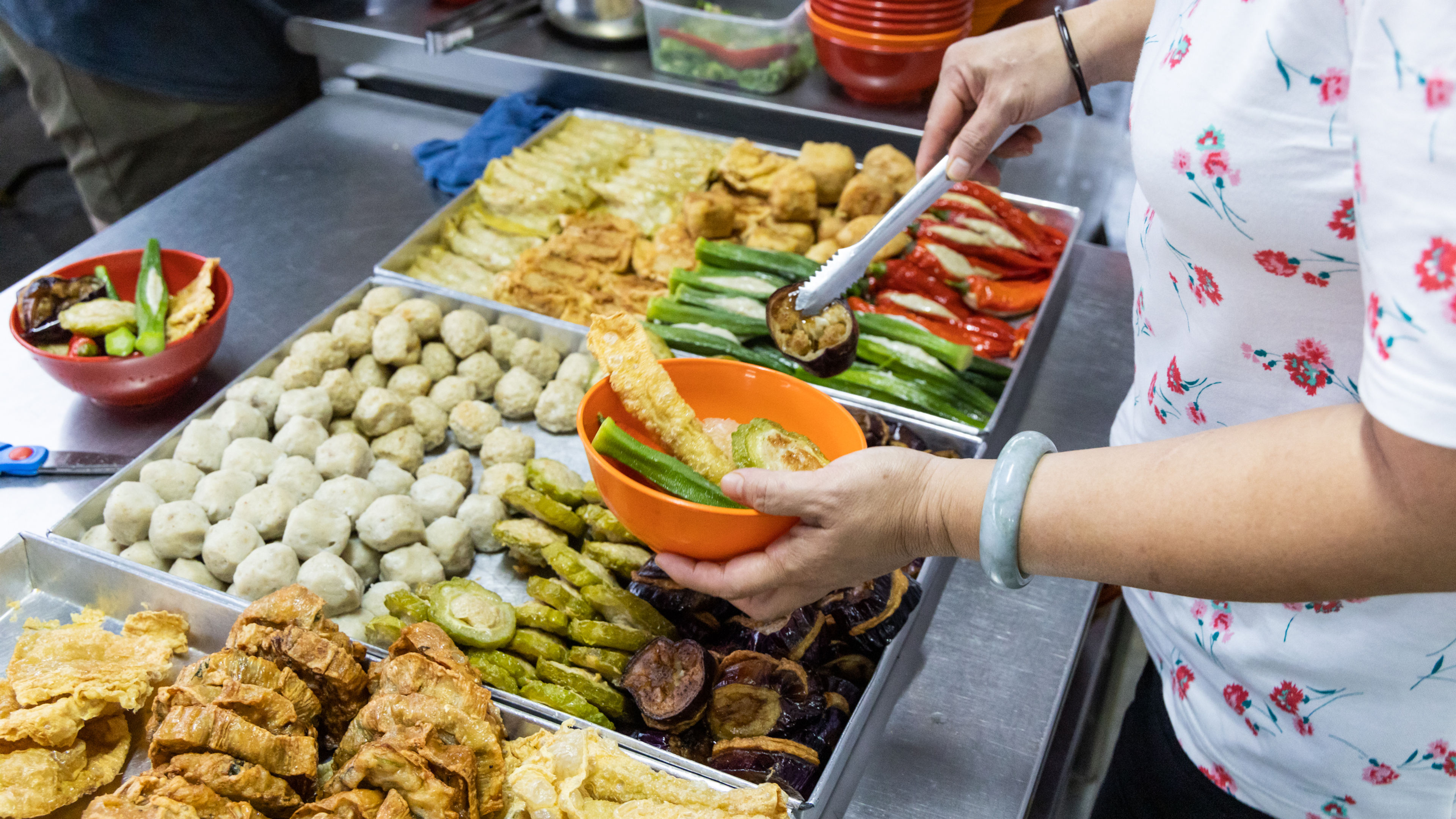 People selecting yong tau foo, delicious fried stuffed fish paste into chilli pepper, okra 