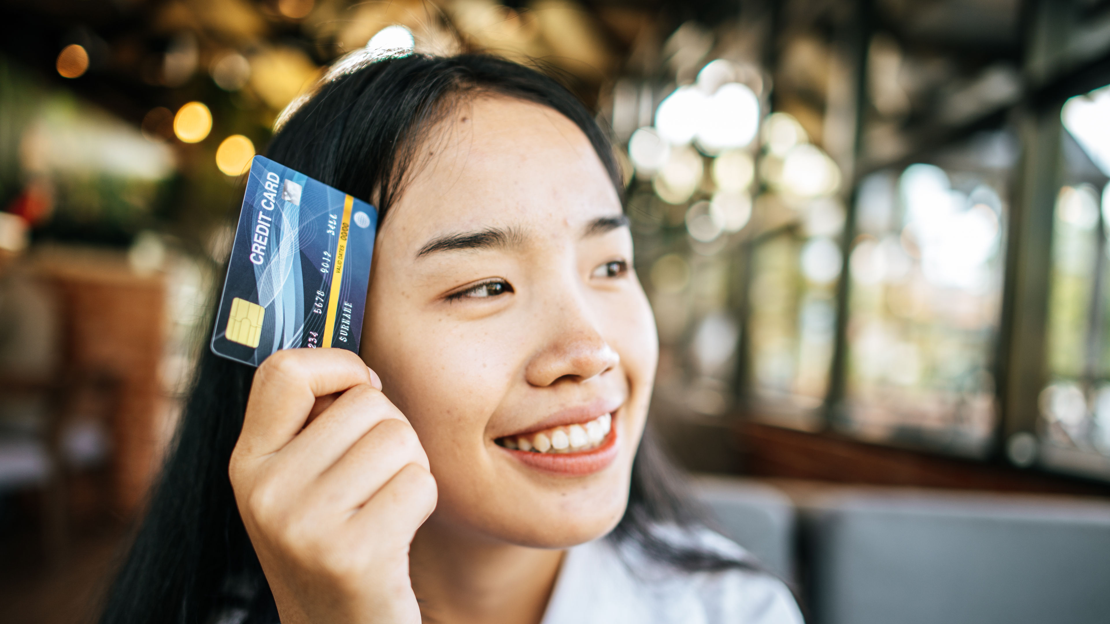 smile woman holding credit card in restaurant 