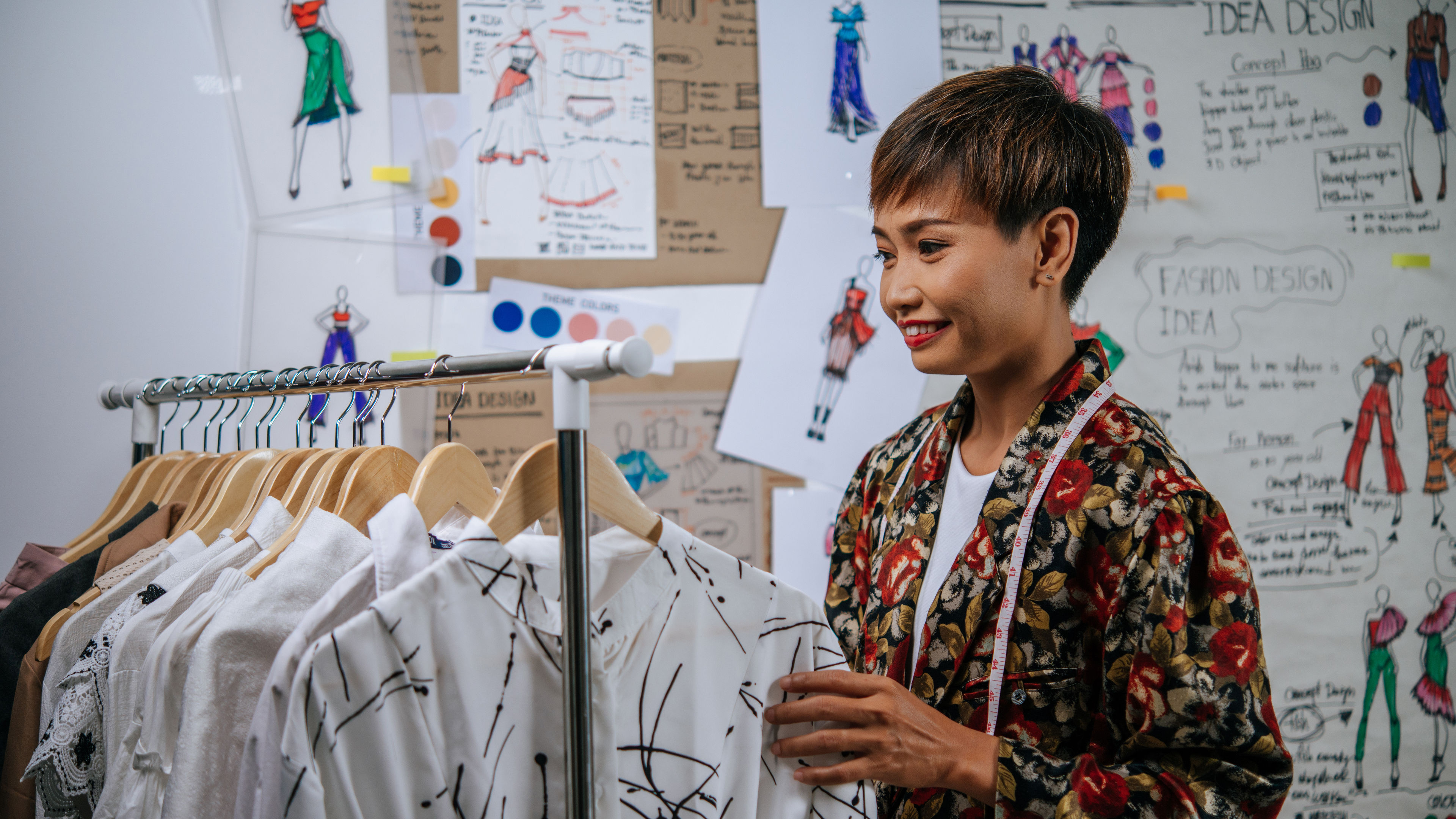 Smiley designer proud with her clothes design on hanger 