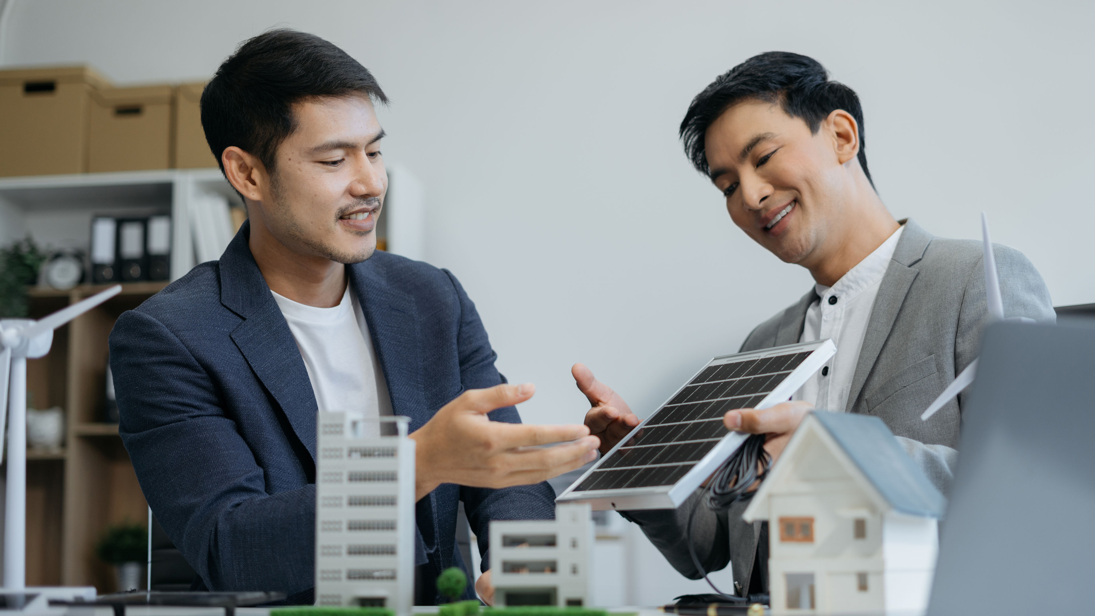 Two professionals discussing a solar panel model. 