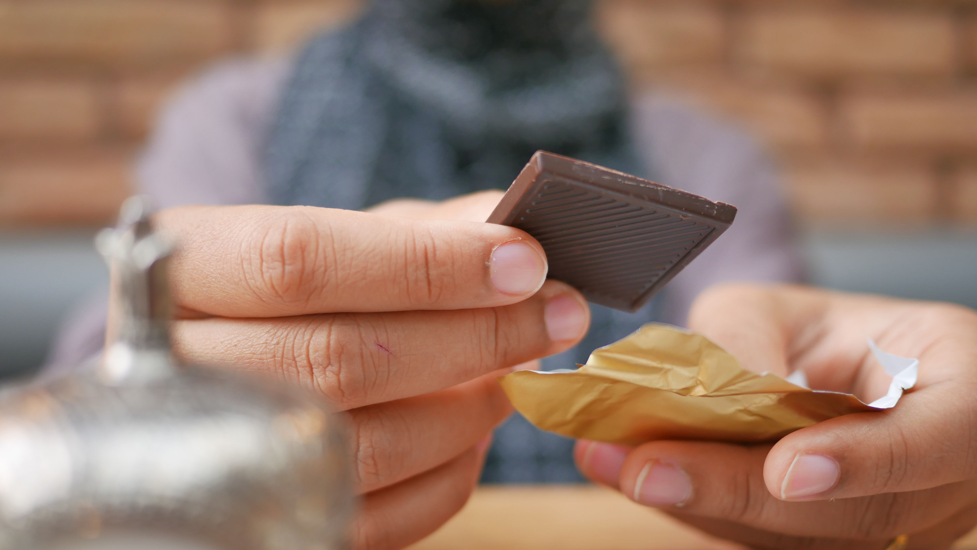 A person carefully unwraps a delicious piece of chocolate 