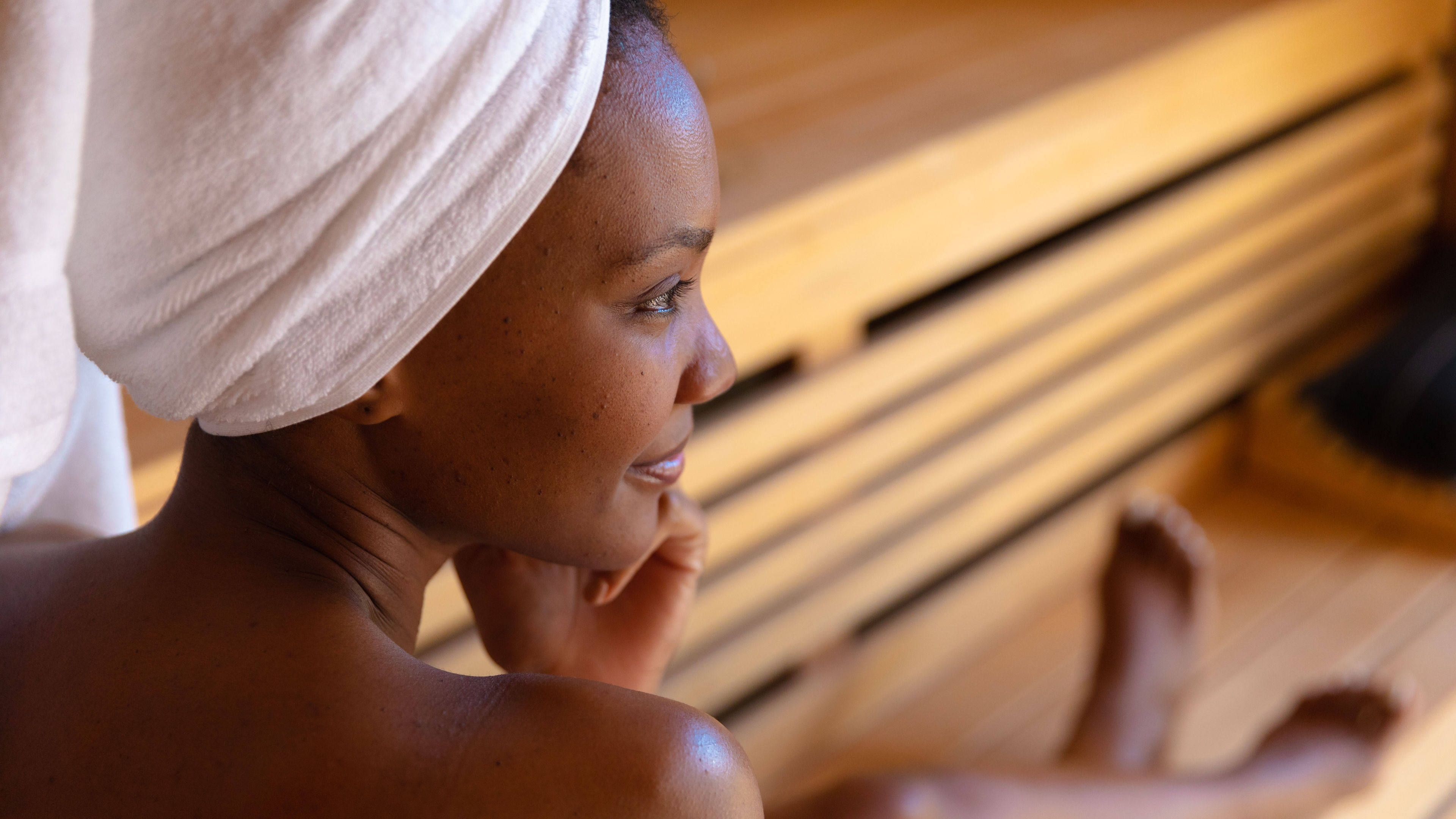 African american woman in a bathrobe relaxing in the sauna 