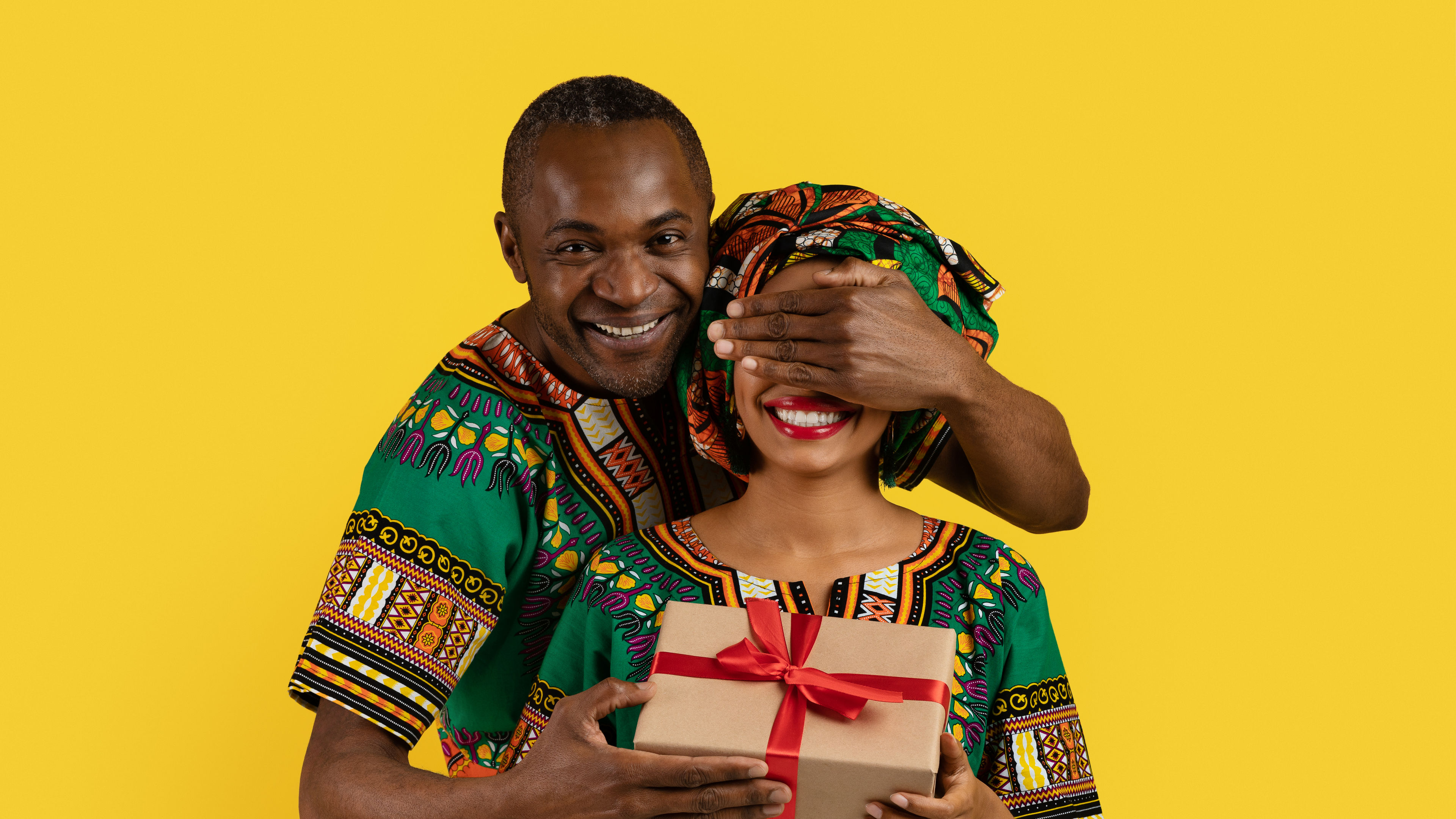 Loving black man make surprise for wife, wearing african outfits 