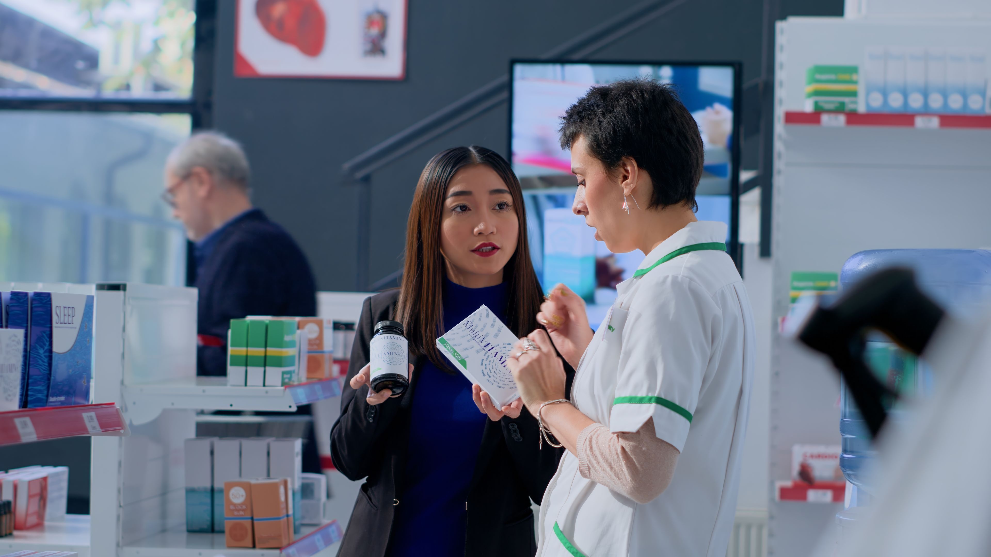 Two people selecting health supplements in a pharmacy 