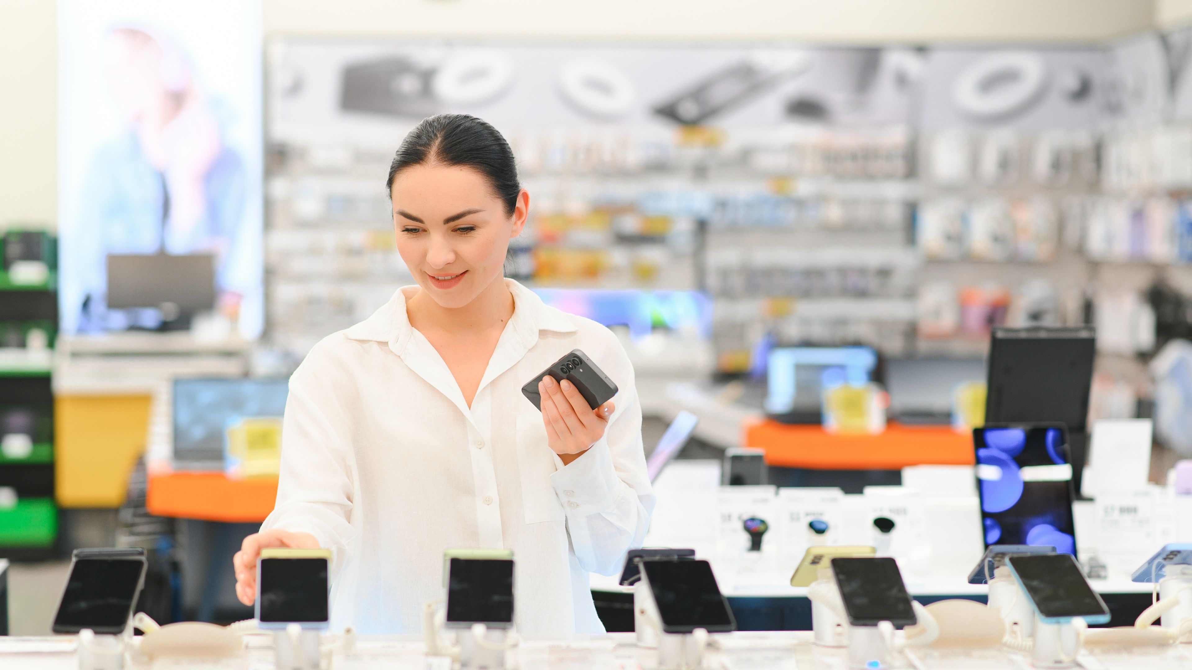  A young woman looking at phones in a shop 