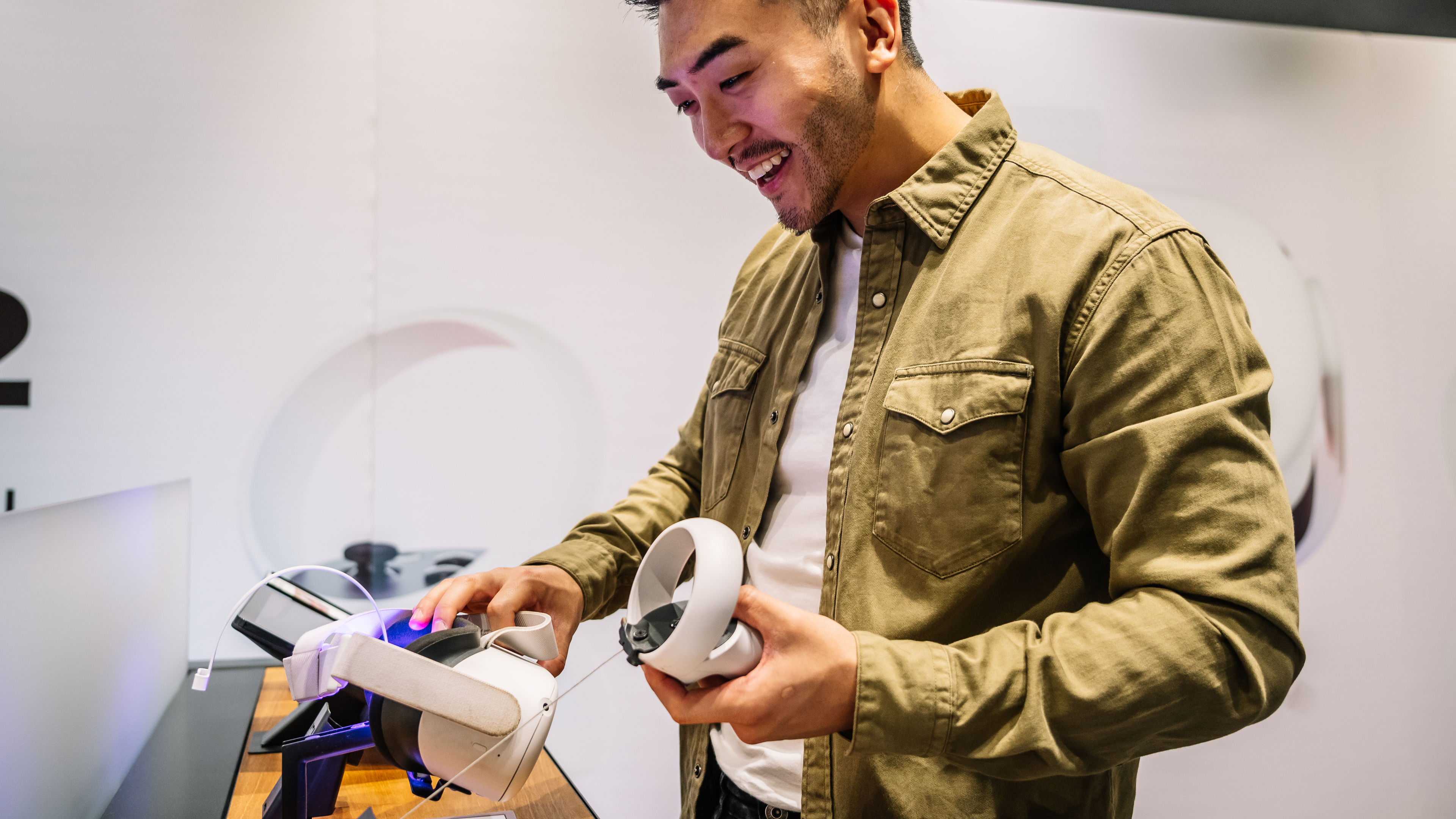 Cheerful ethnic man choosing VR headset in store 