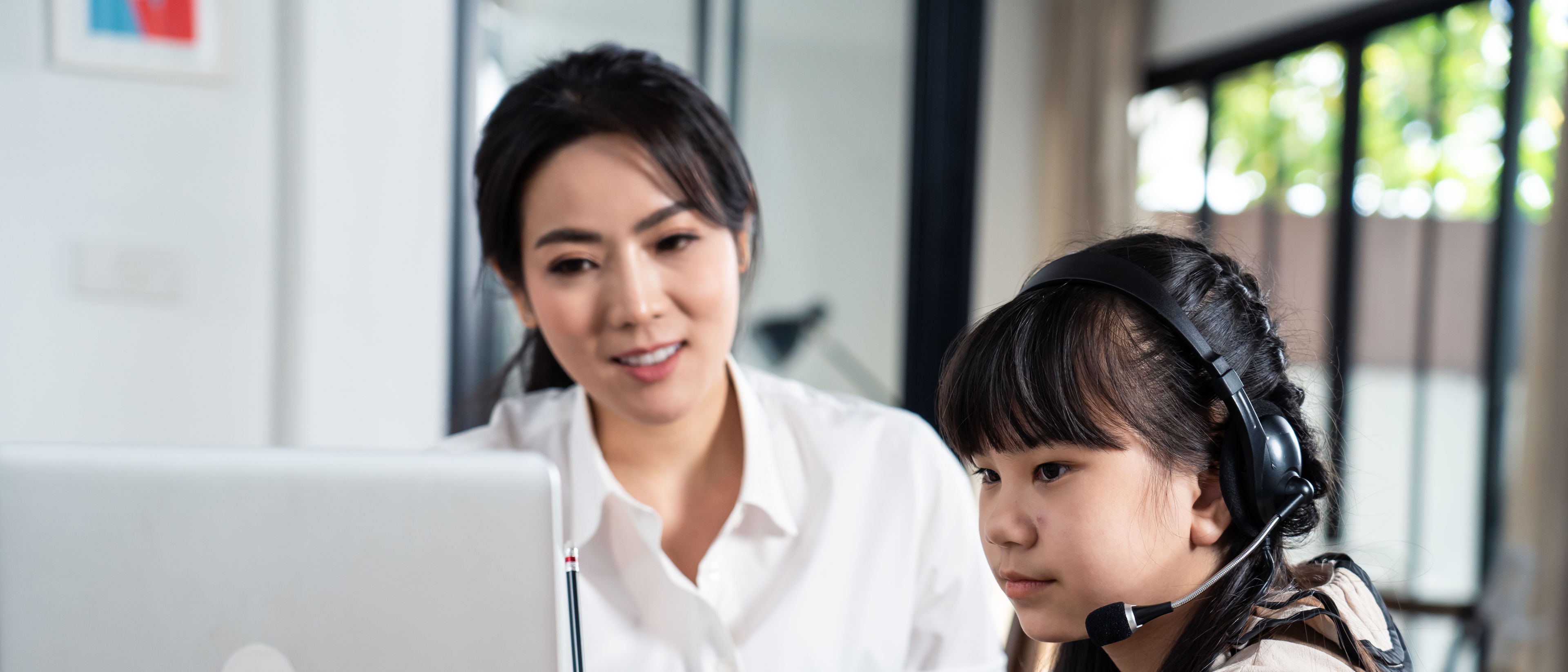 Kid looking computer and writing note