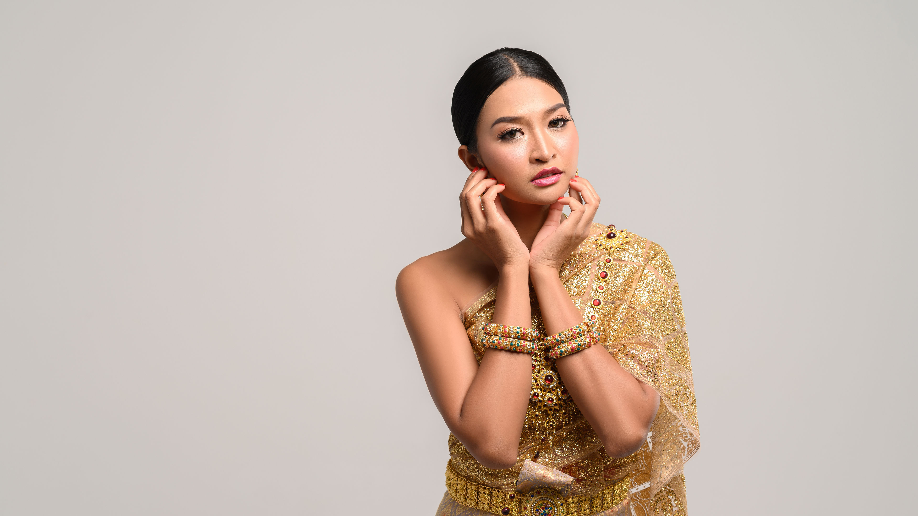 The girl wears Thai dress and hands touch the face. 