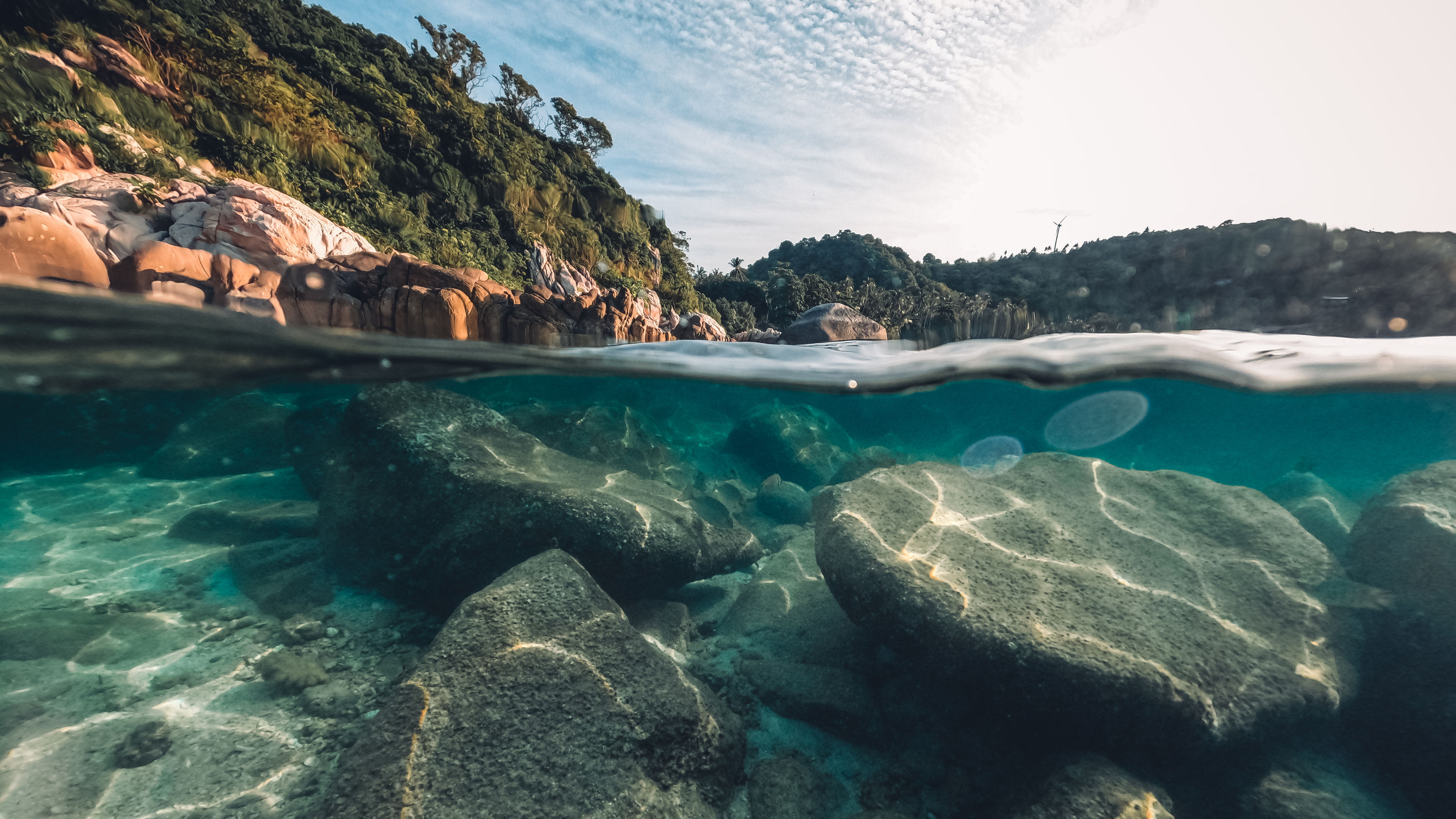 Underwater view beneath the waves at a tropical island beach.  