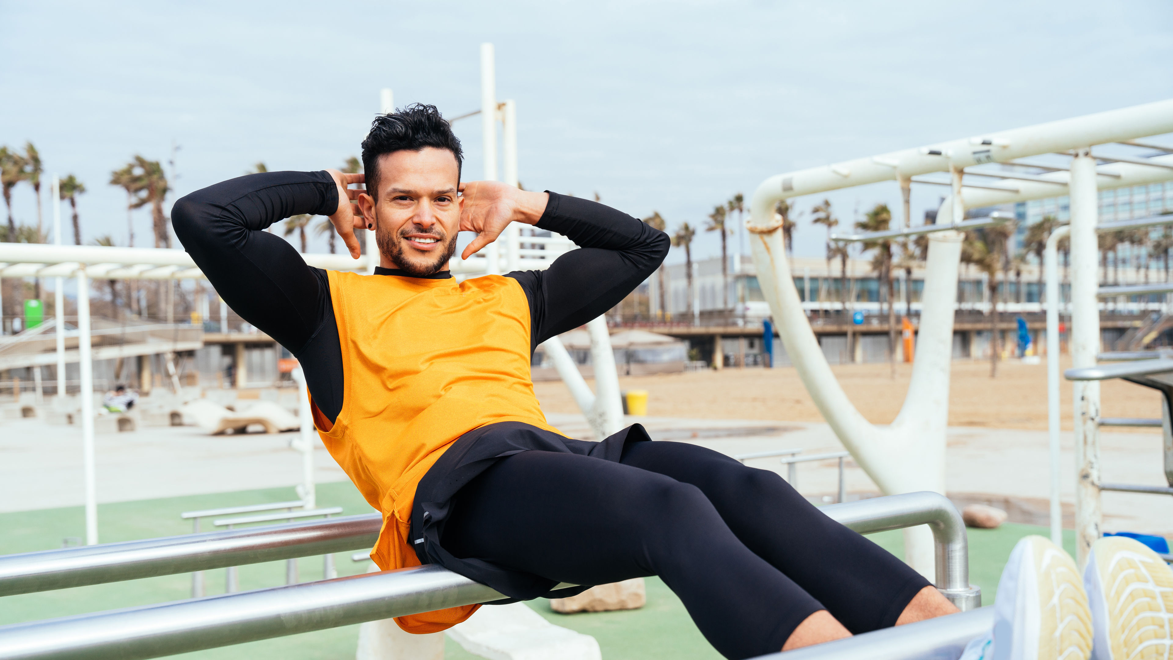 An athlete training on an open gym in a beach.