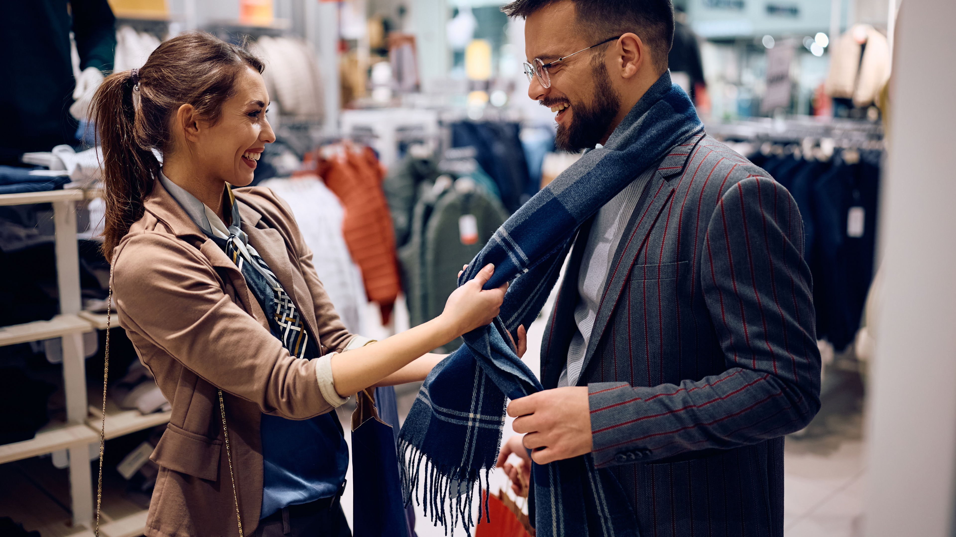 Young couple having fun while shopping in a clothing store at the mall.