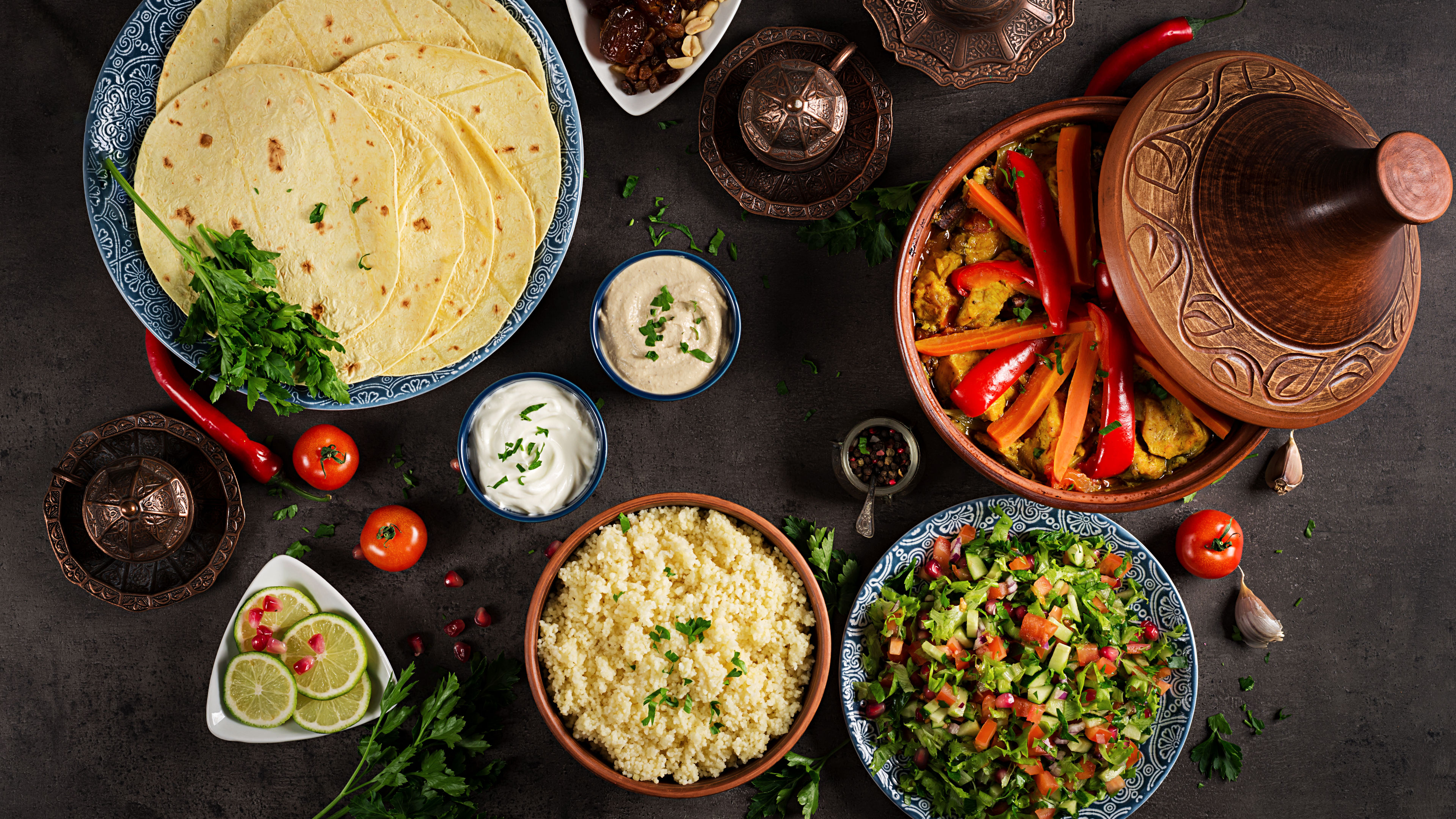 A variety of traditional meals and dishes arranged on a dark wooden table.