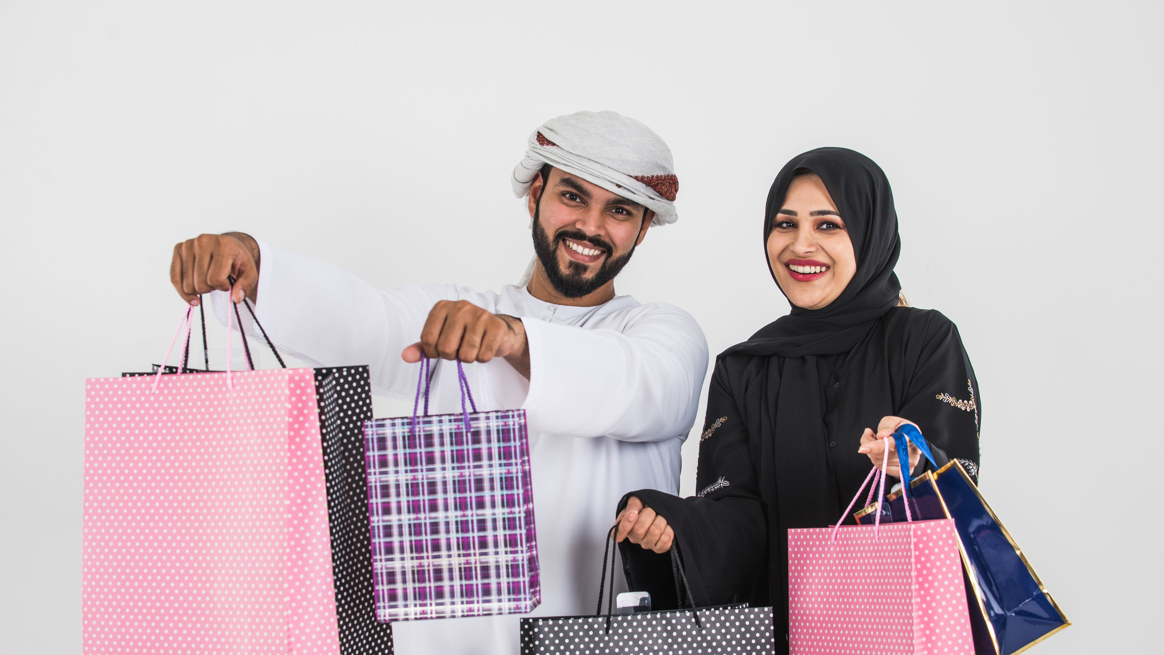 A happy man and a young woman with colorful shopping bags