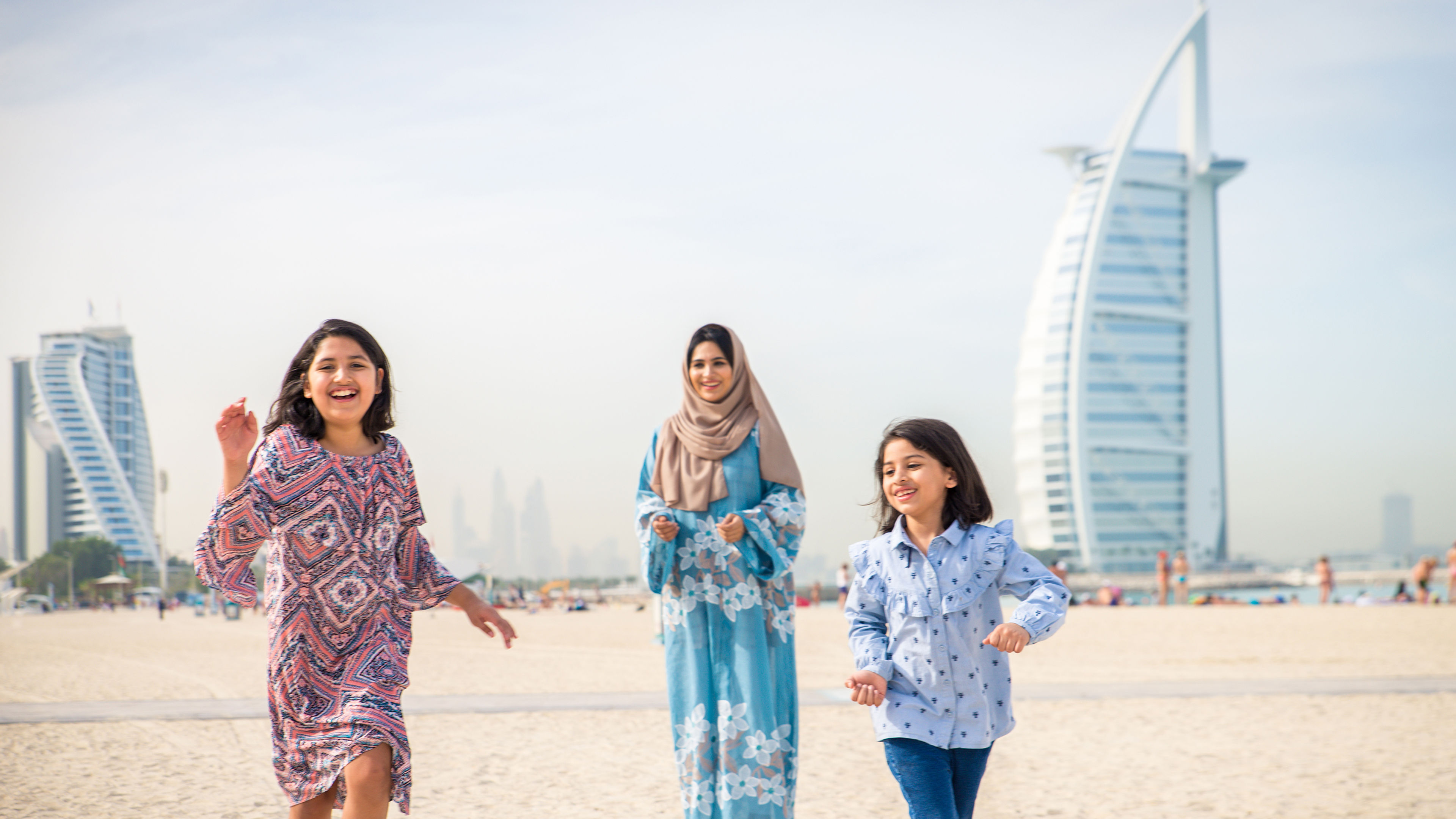 A happy woman and her children running  