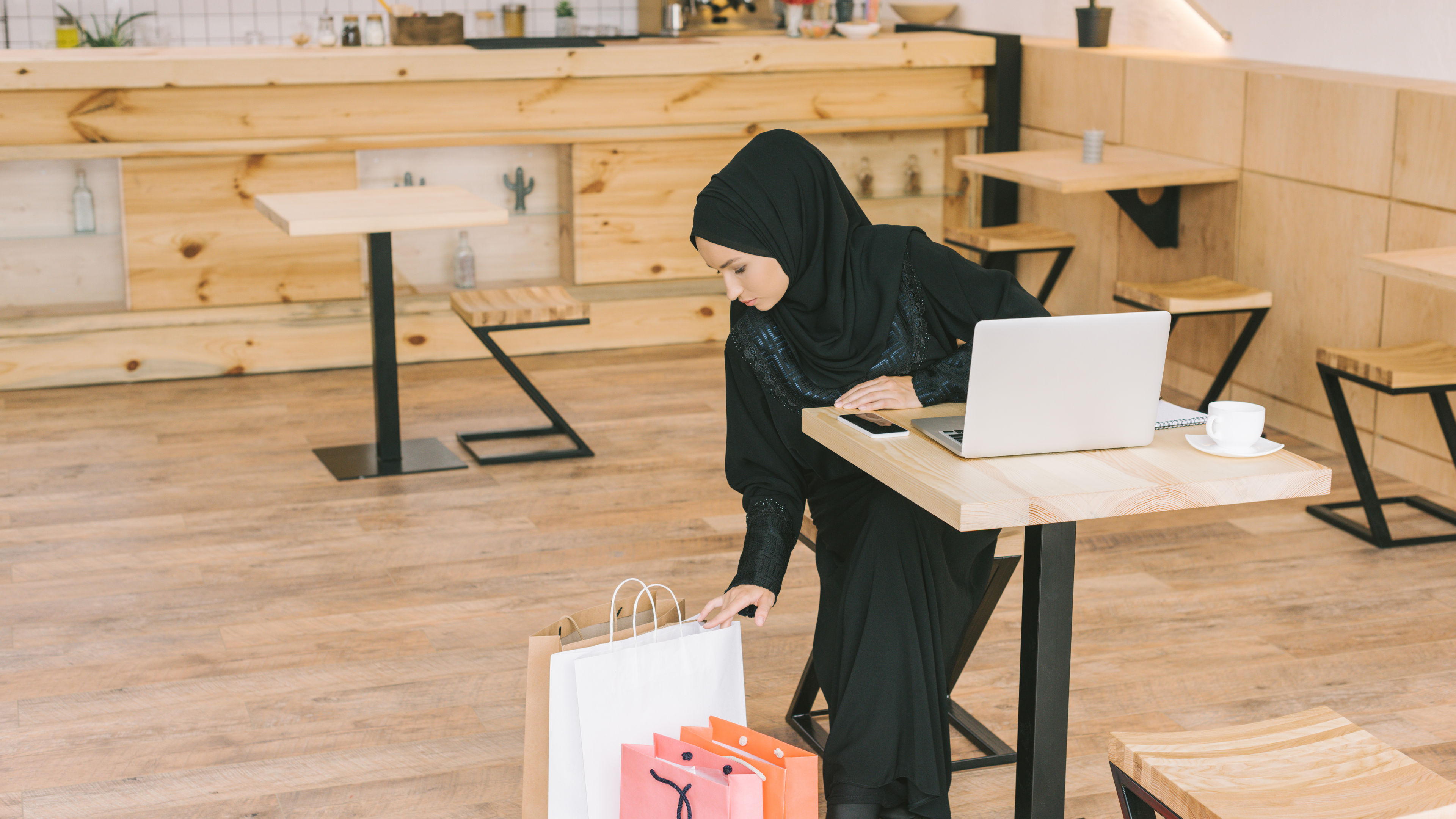 An arabian woman looking at shopping bags after purchasing