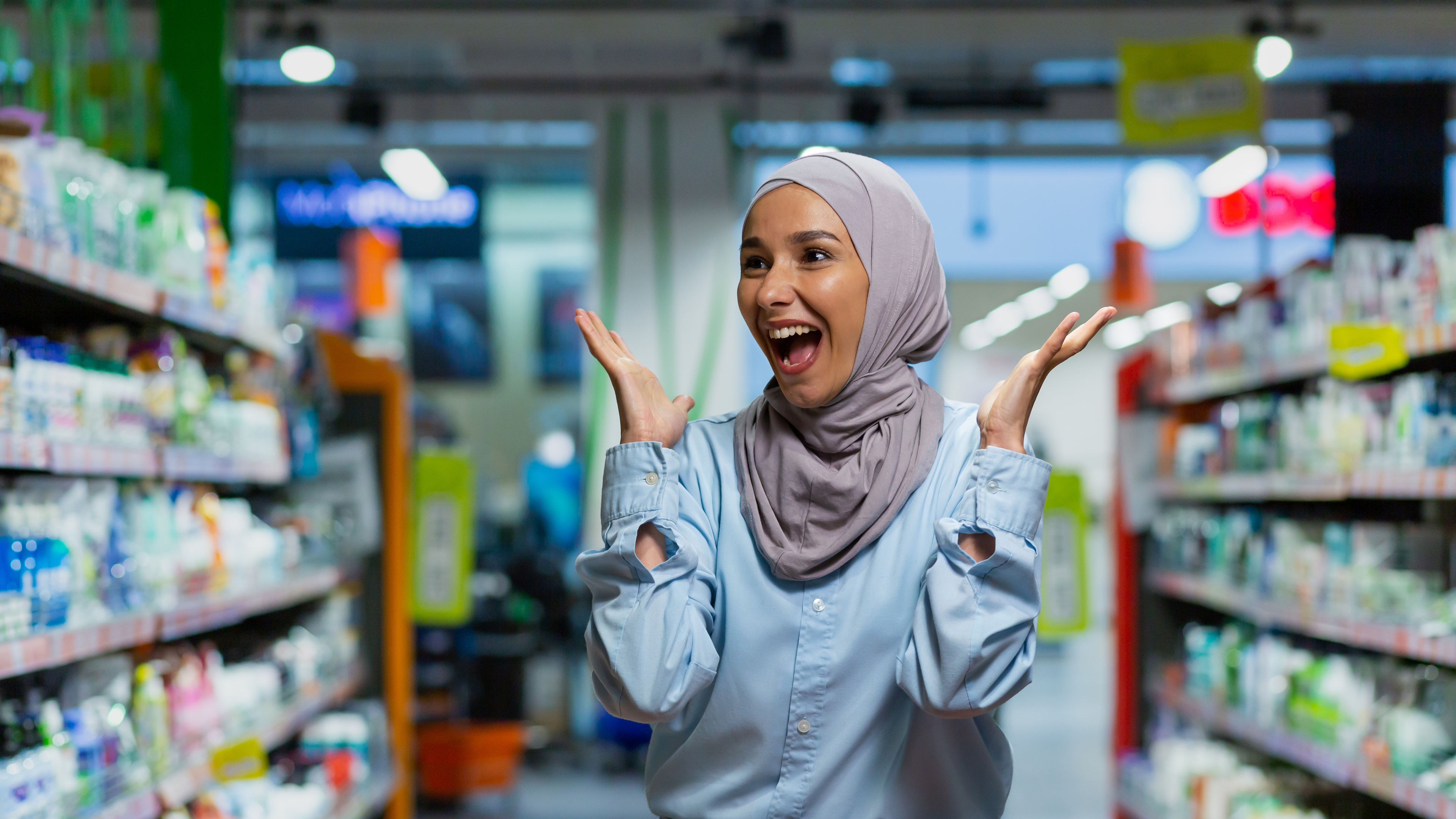 A happy woman shopping with cart in hand