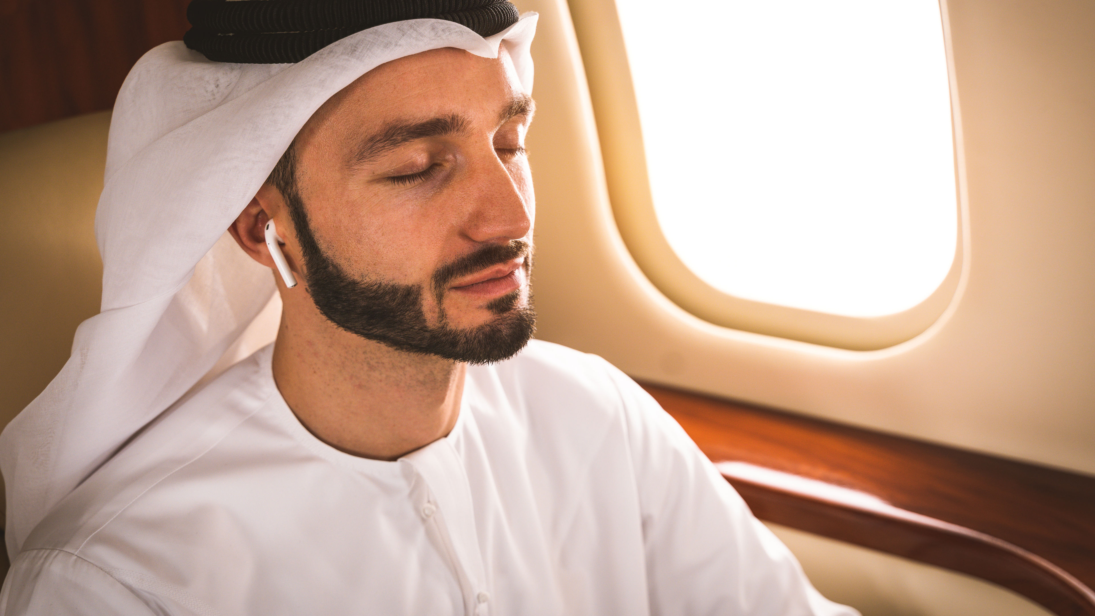 Arabian man wearing kandora flying on private jet 