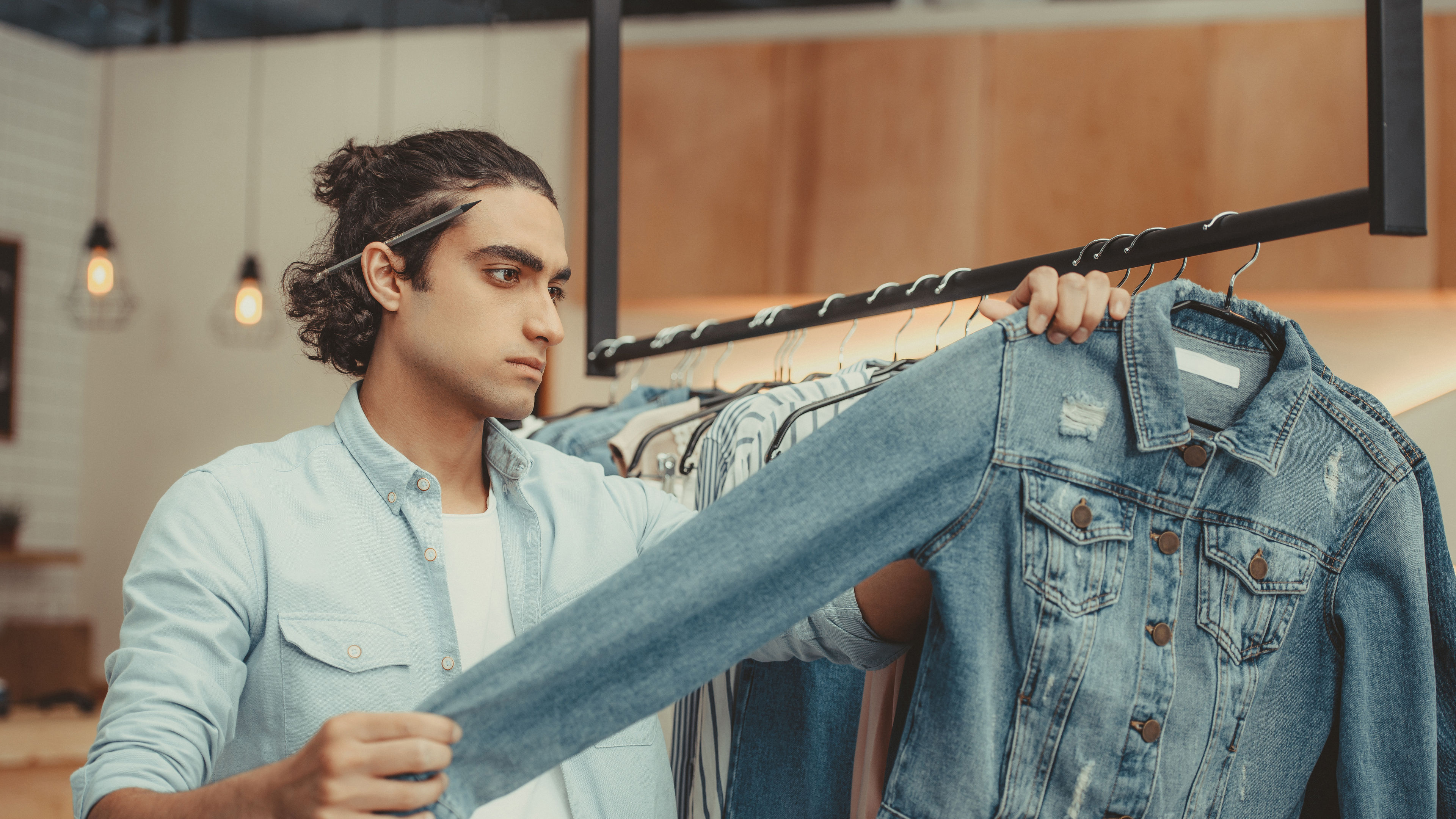 Man inspecting a denim jacket.