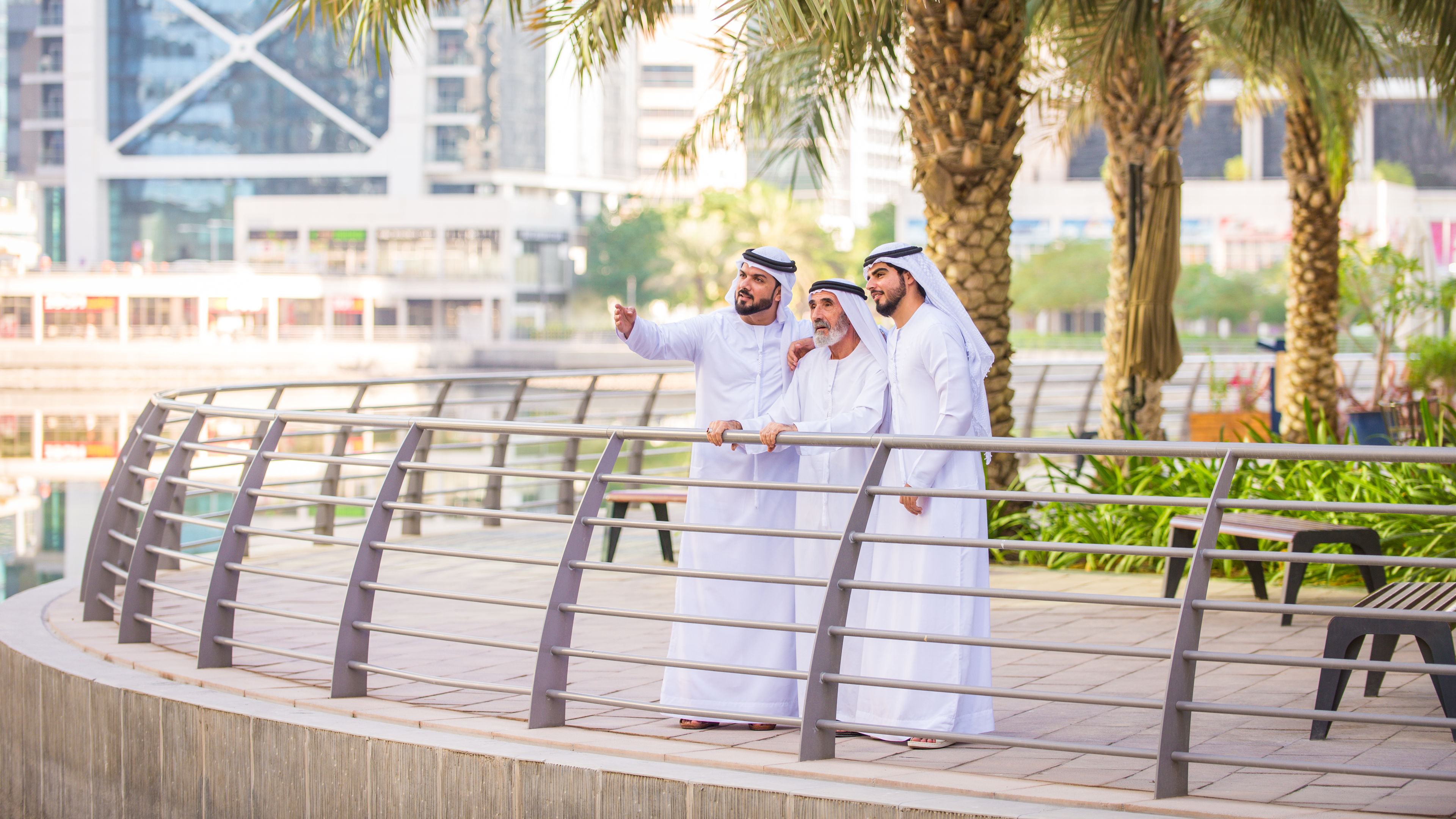 Three happy Arabians looking at a view in the city