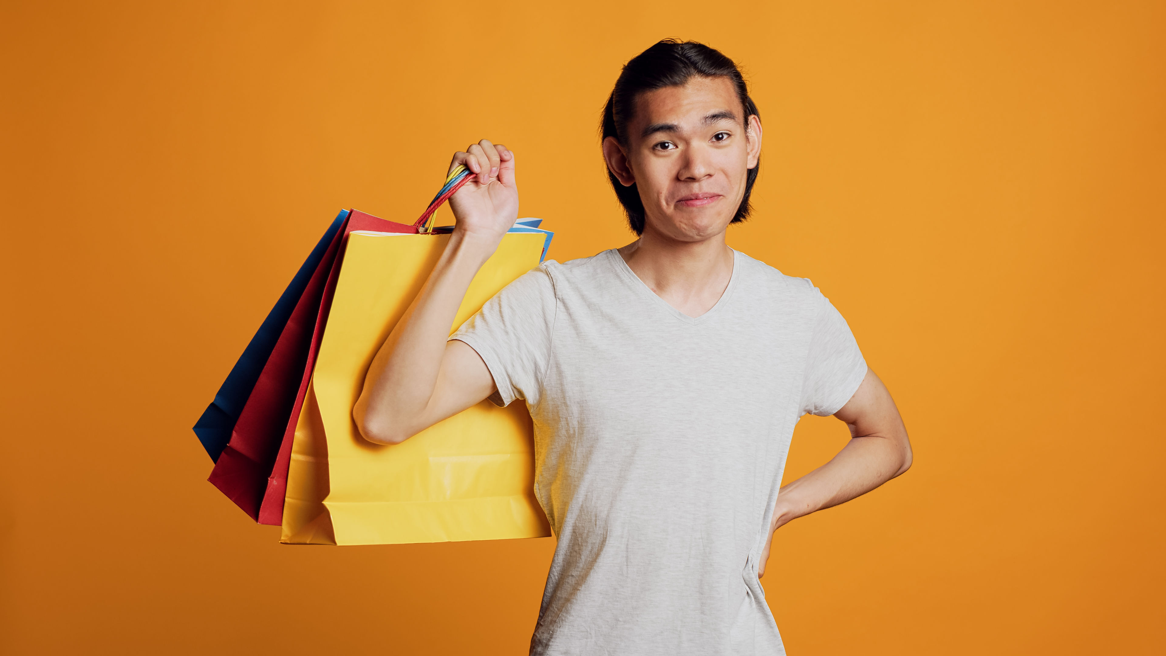 A delighted man proudly carrying shopping bags after a successful purchase.
