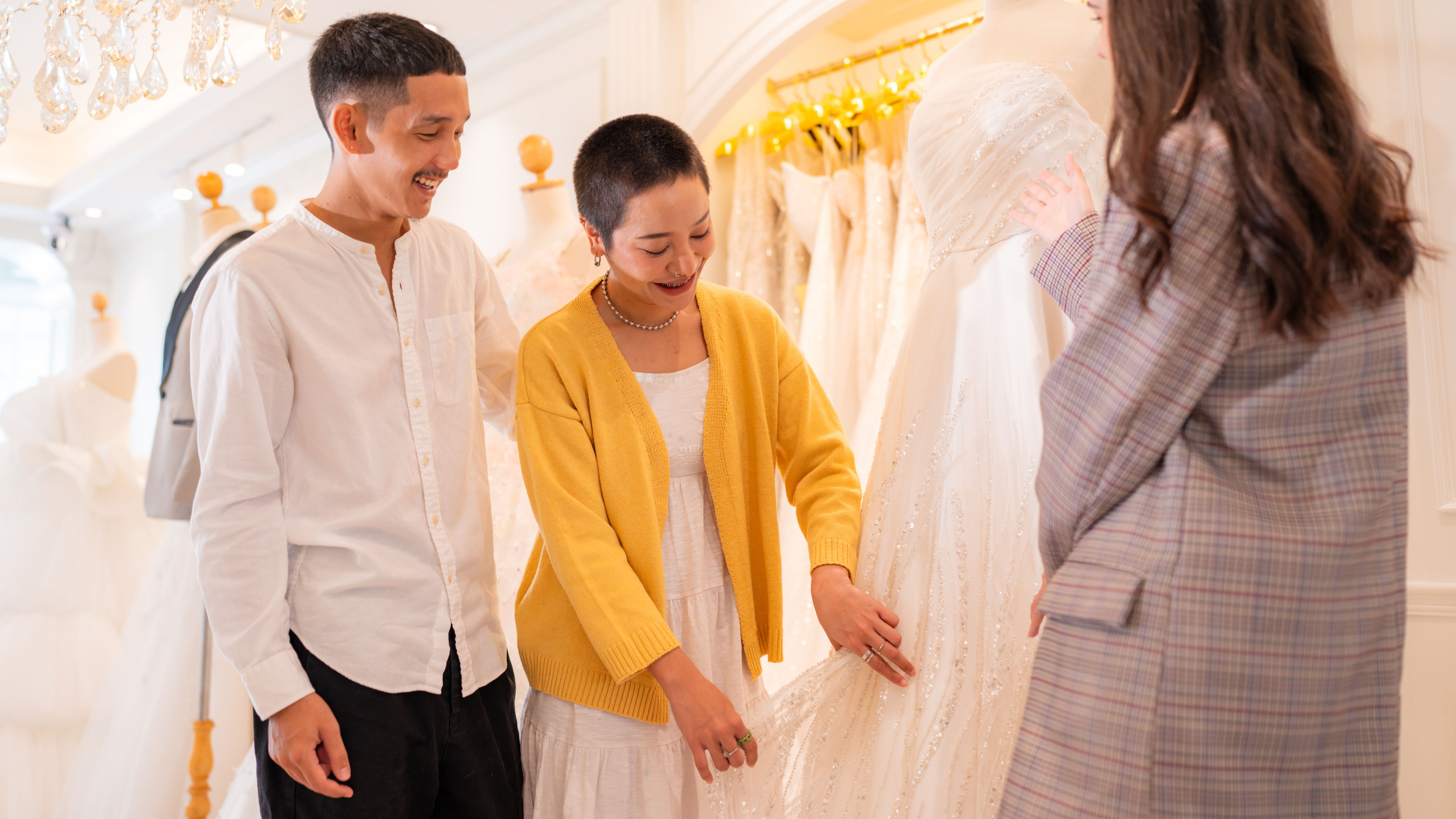 A happy couple shopping for white gowns 