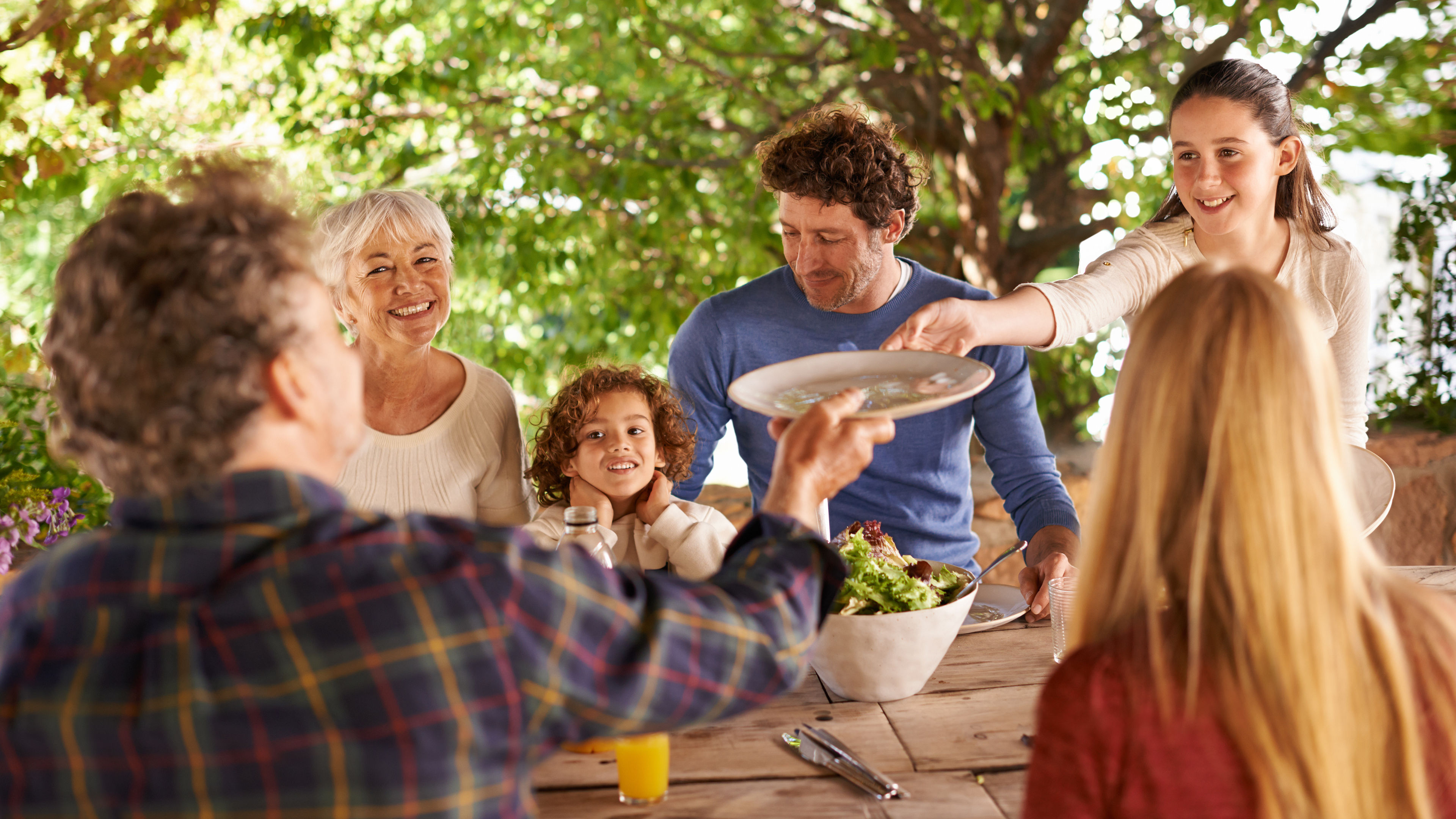 A family eating together outdoors.
