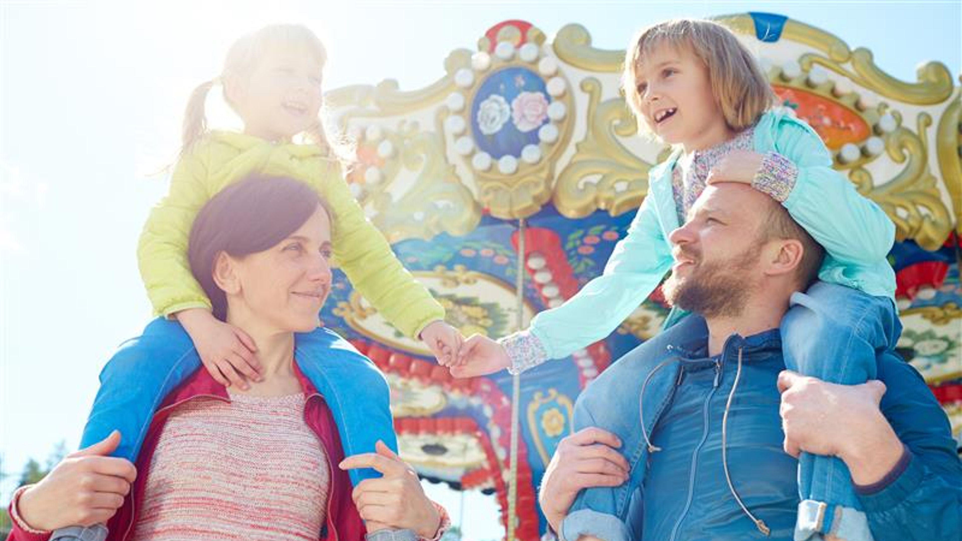 A family of four in an amusement park. 