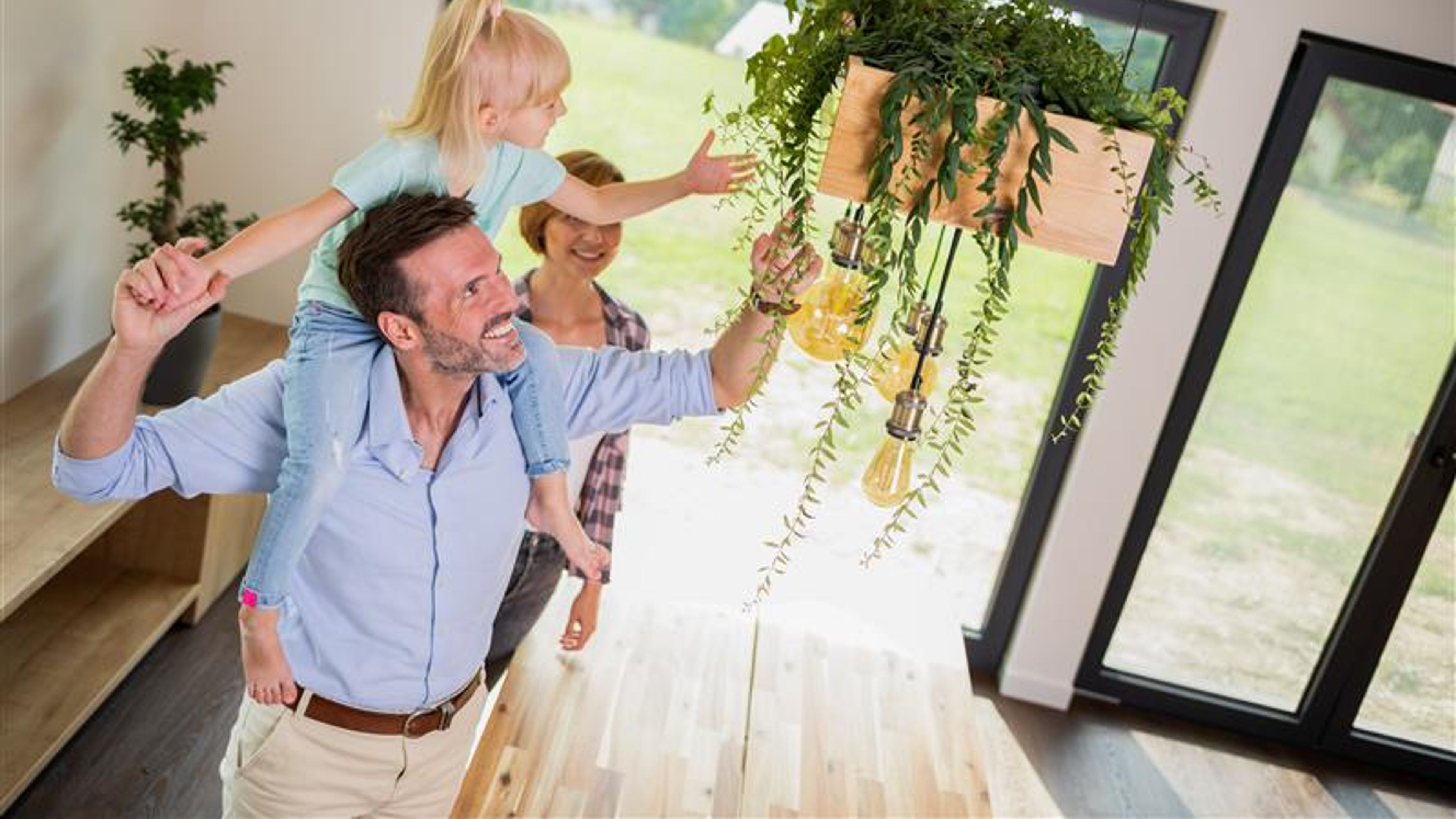 A family of three looking at an ornamental plant in home