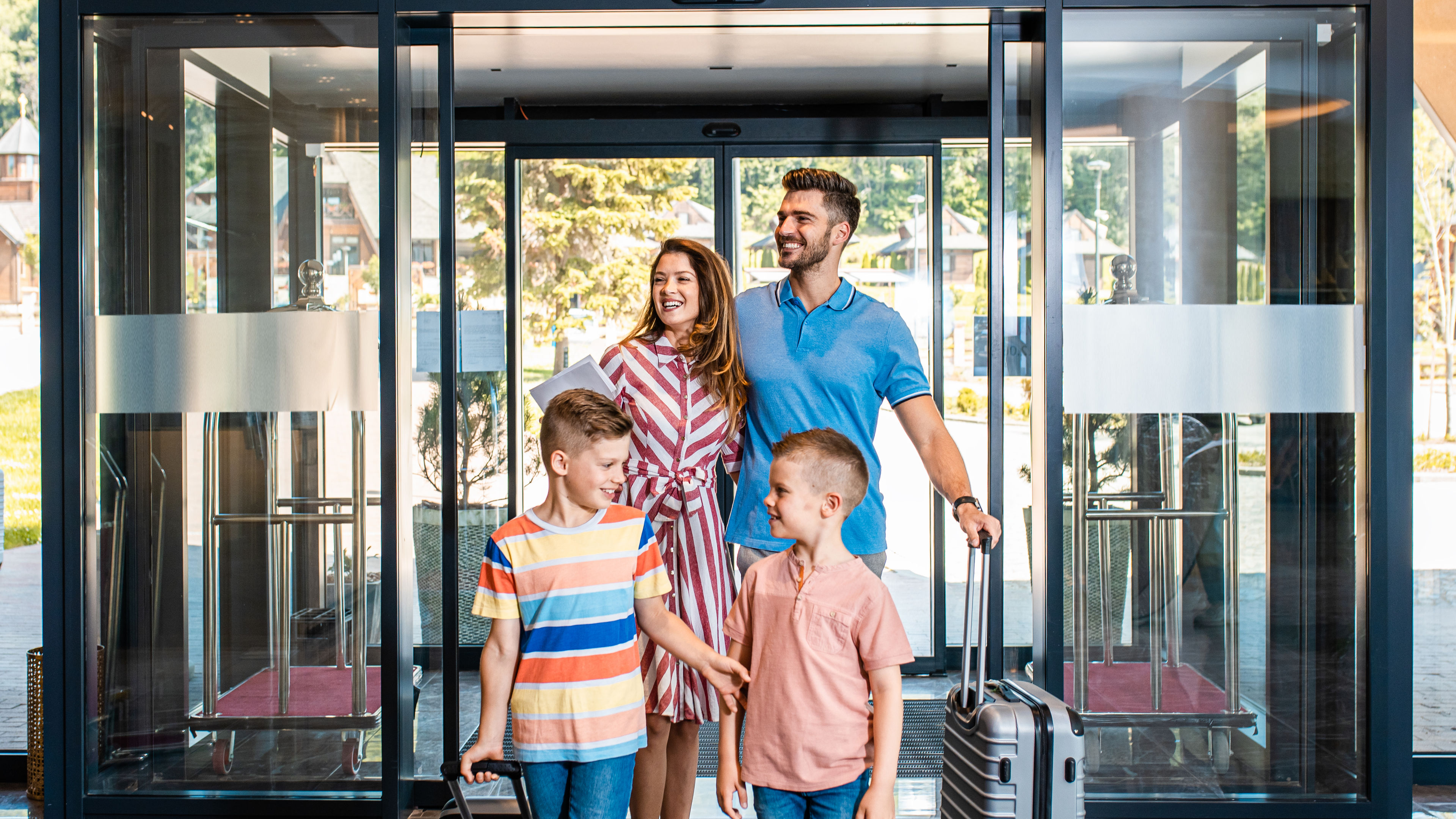 A happy family is entering a hotel.
