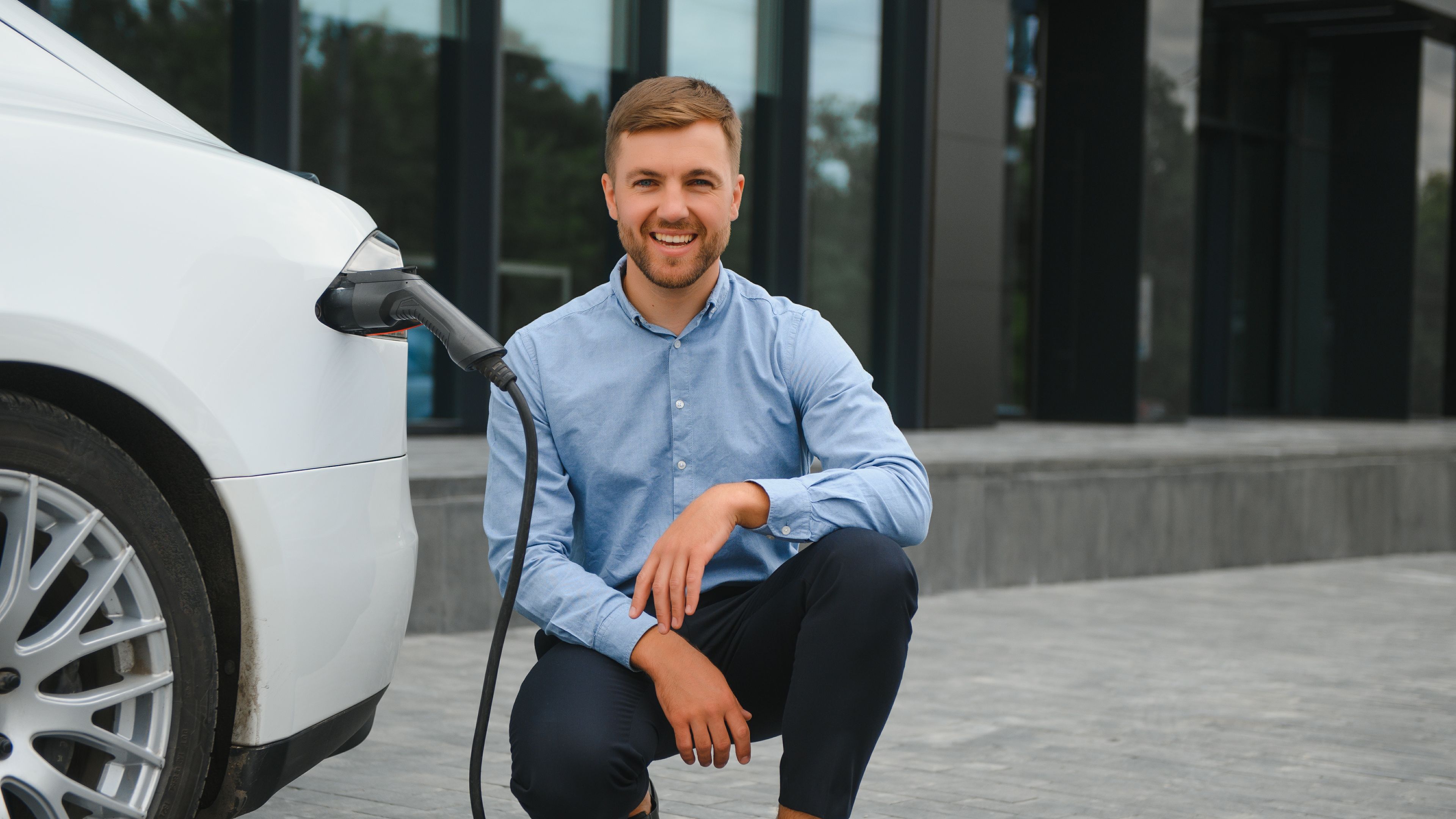 A man charging an electric vehicle 