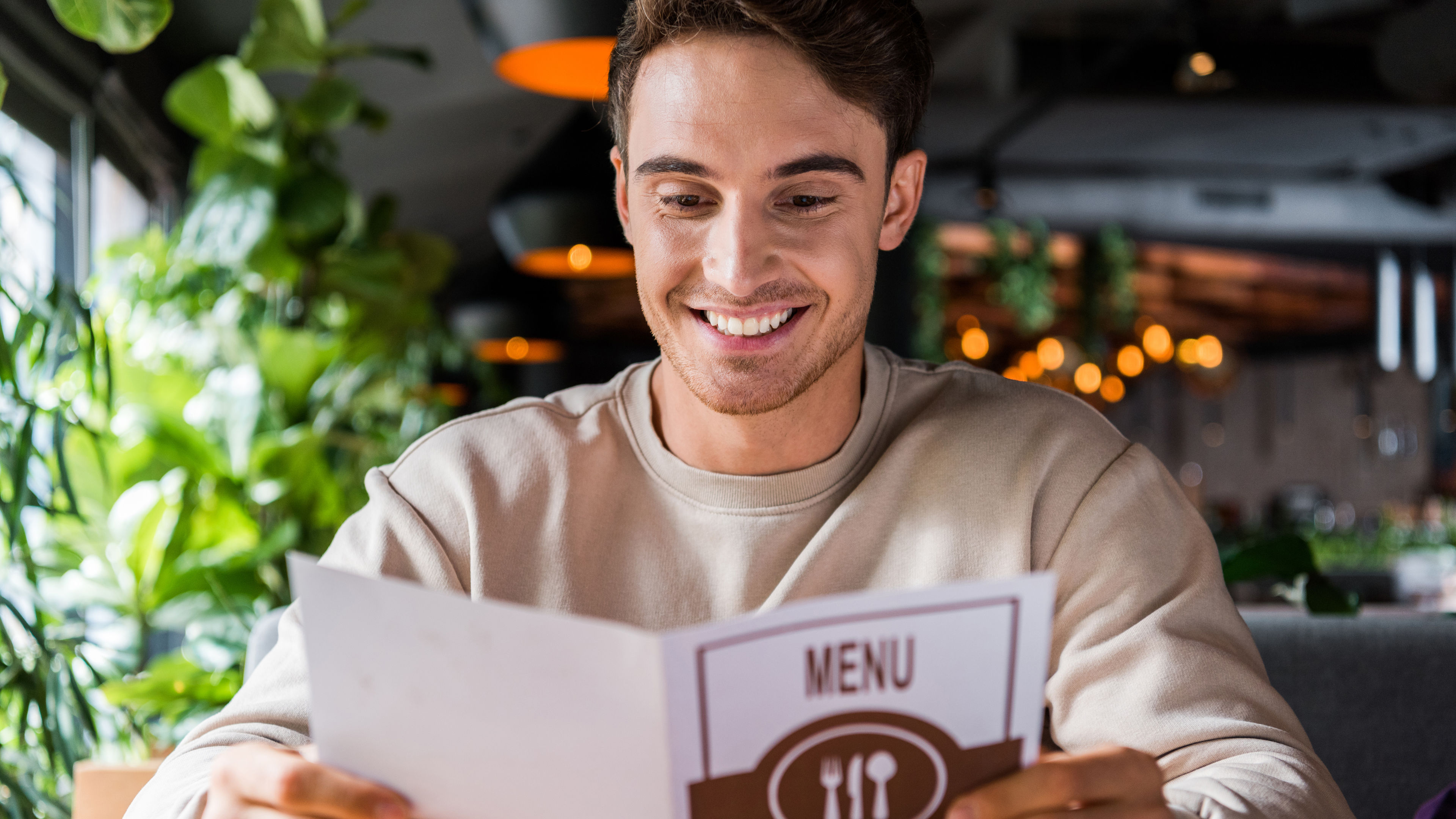 A happy man looking at a menu in a hotel 
