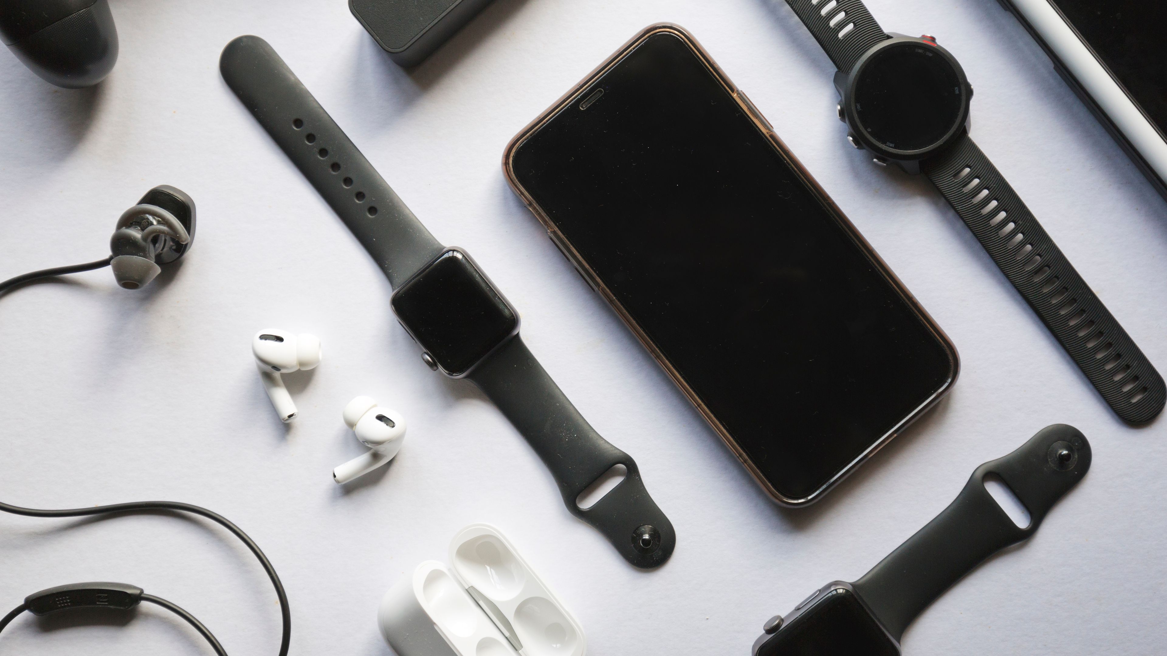 A modern workspace with a laptop, phone, and neatly arranged gadgets on a desk. 