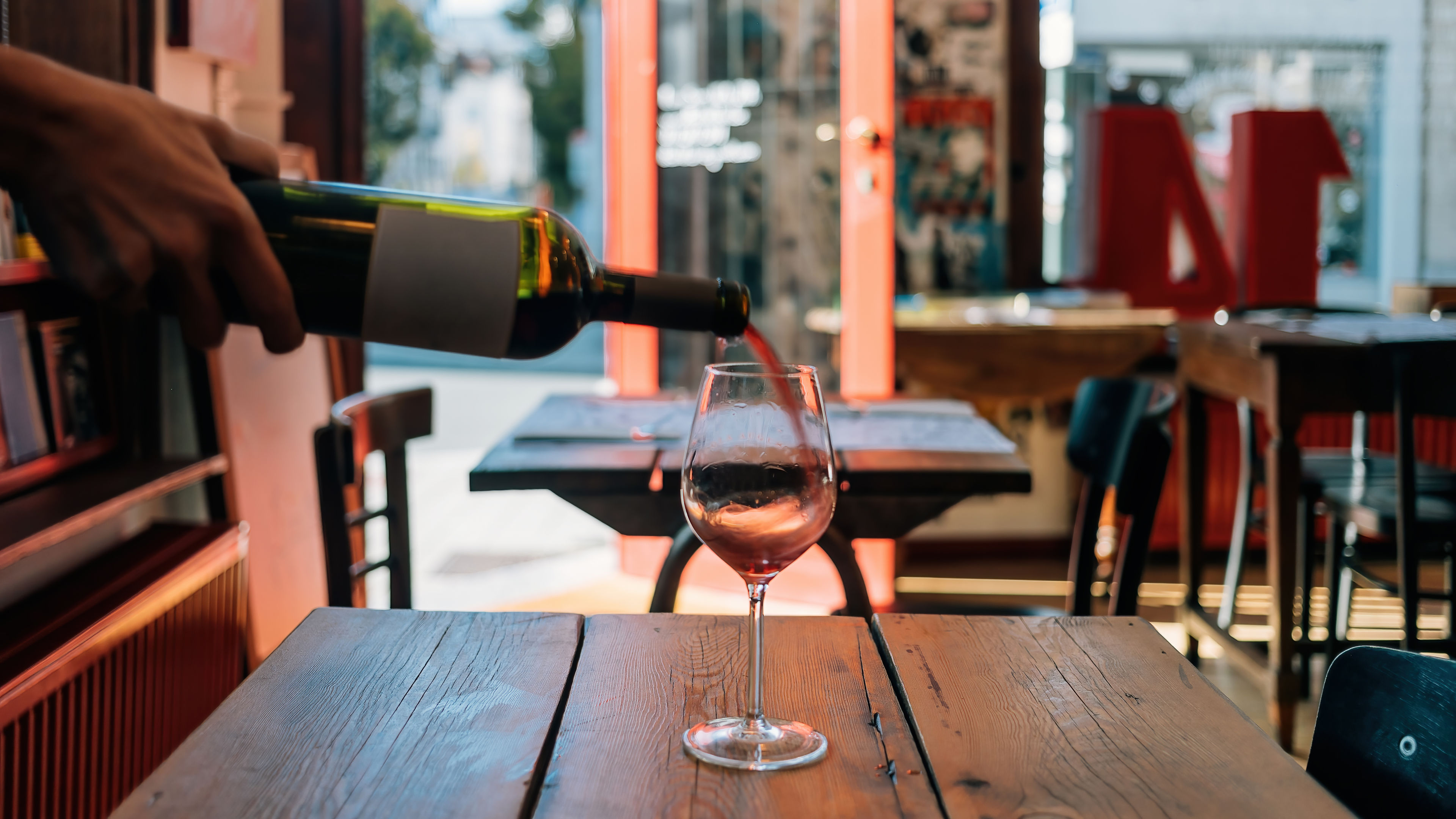 A wine glass is placed on a wooden table 