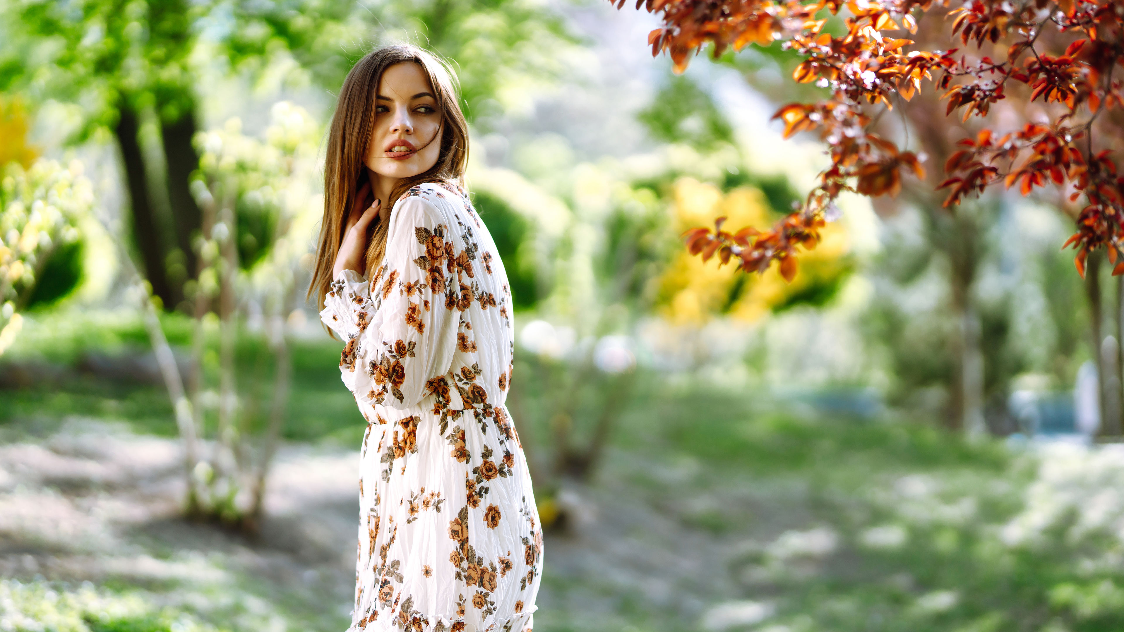 A woman enjoys a spring day by a blooming tree. 