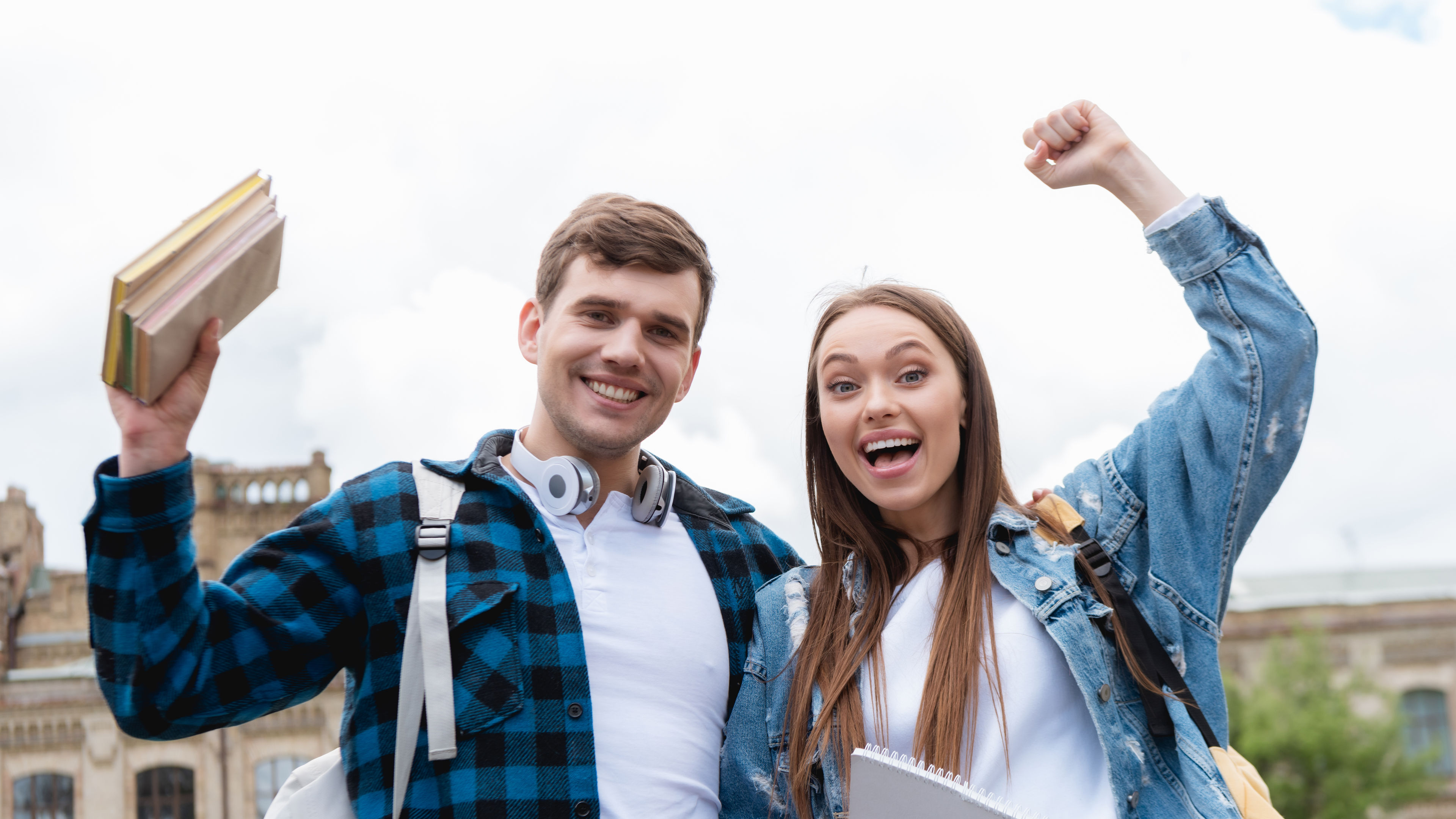 cheerful students celebrating triumph while looking at camera 