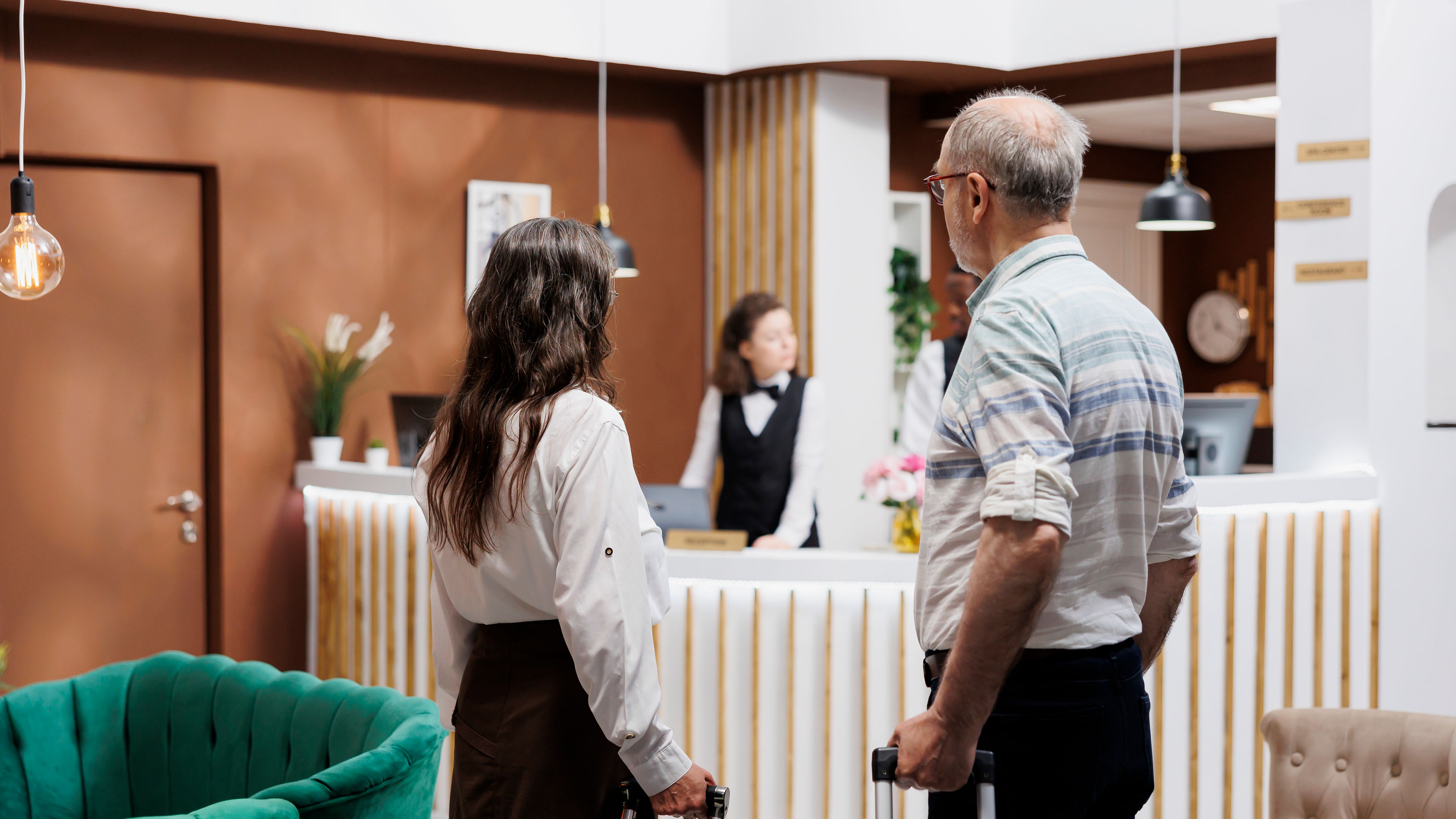 A happy couple waiting at the reception of a hotel 