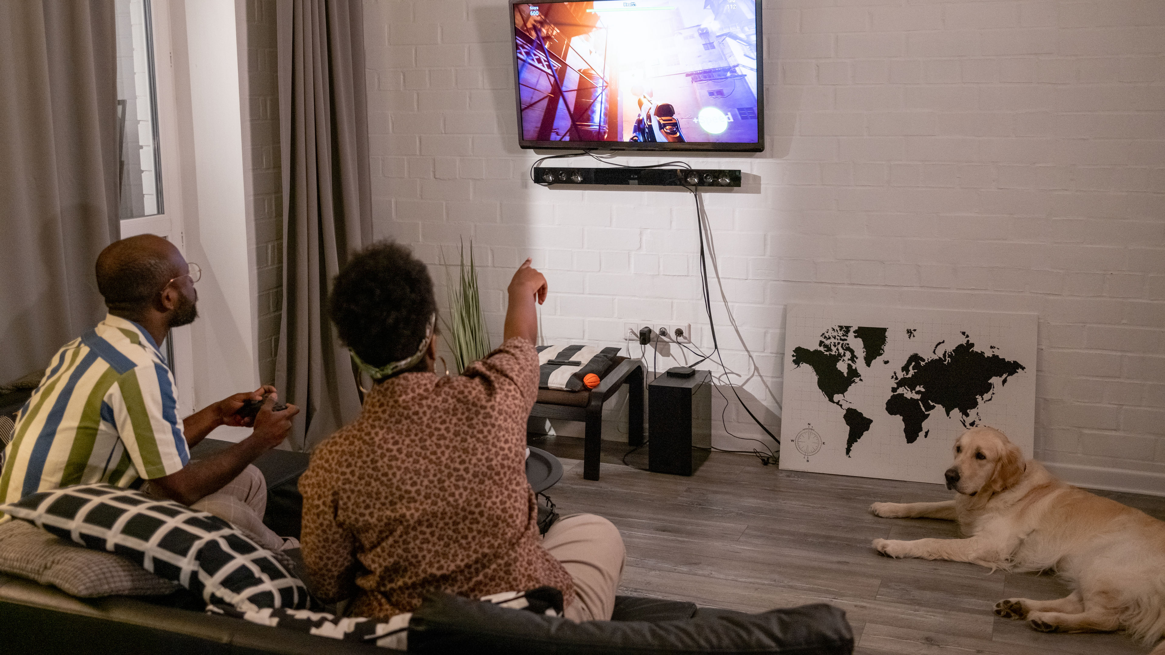 A couple enjoying a video game together at home, laughing and competing in a cosy setting. 