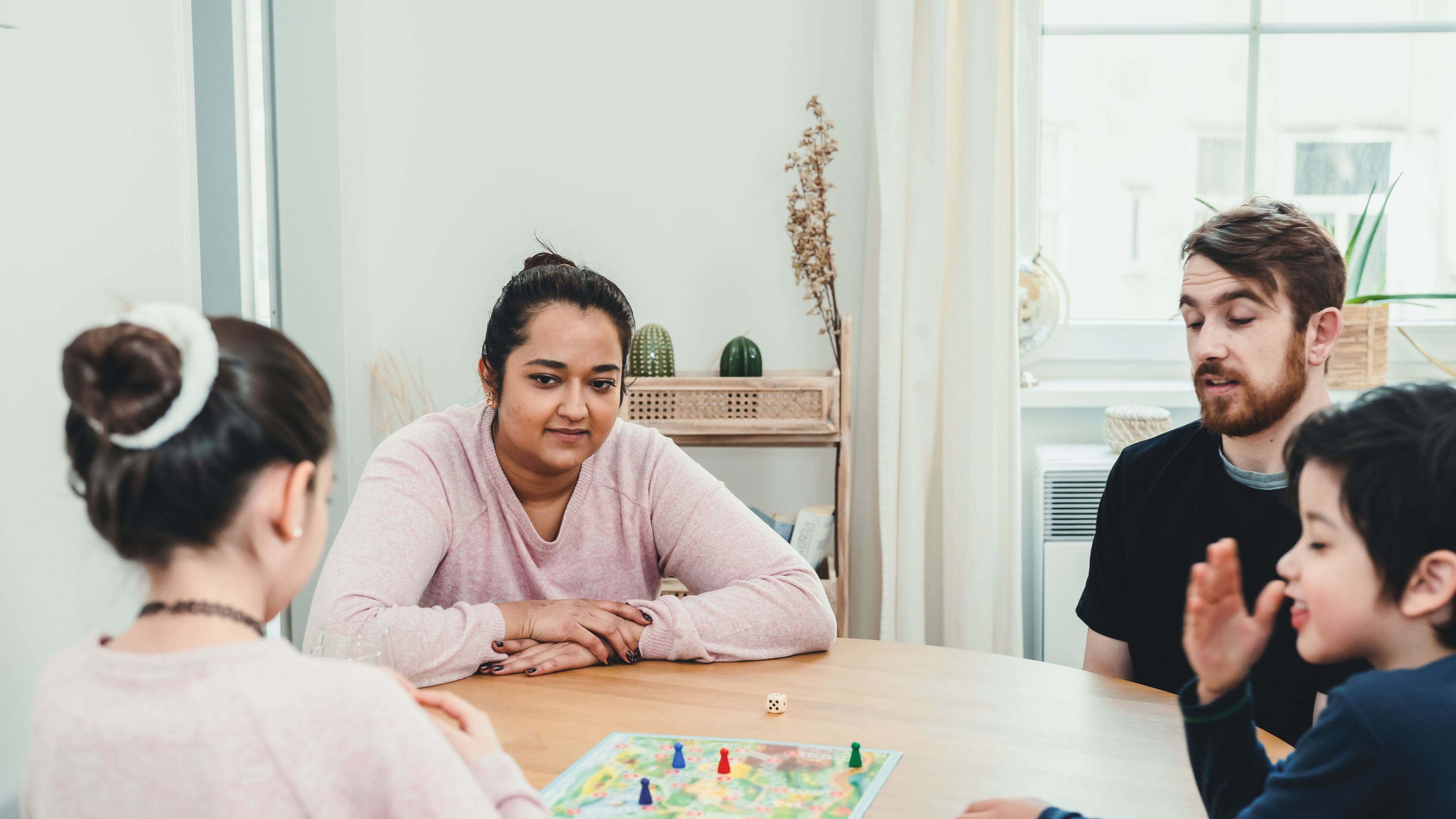 Family spending time at home playing the board game 