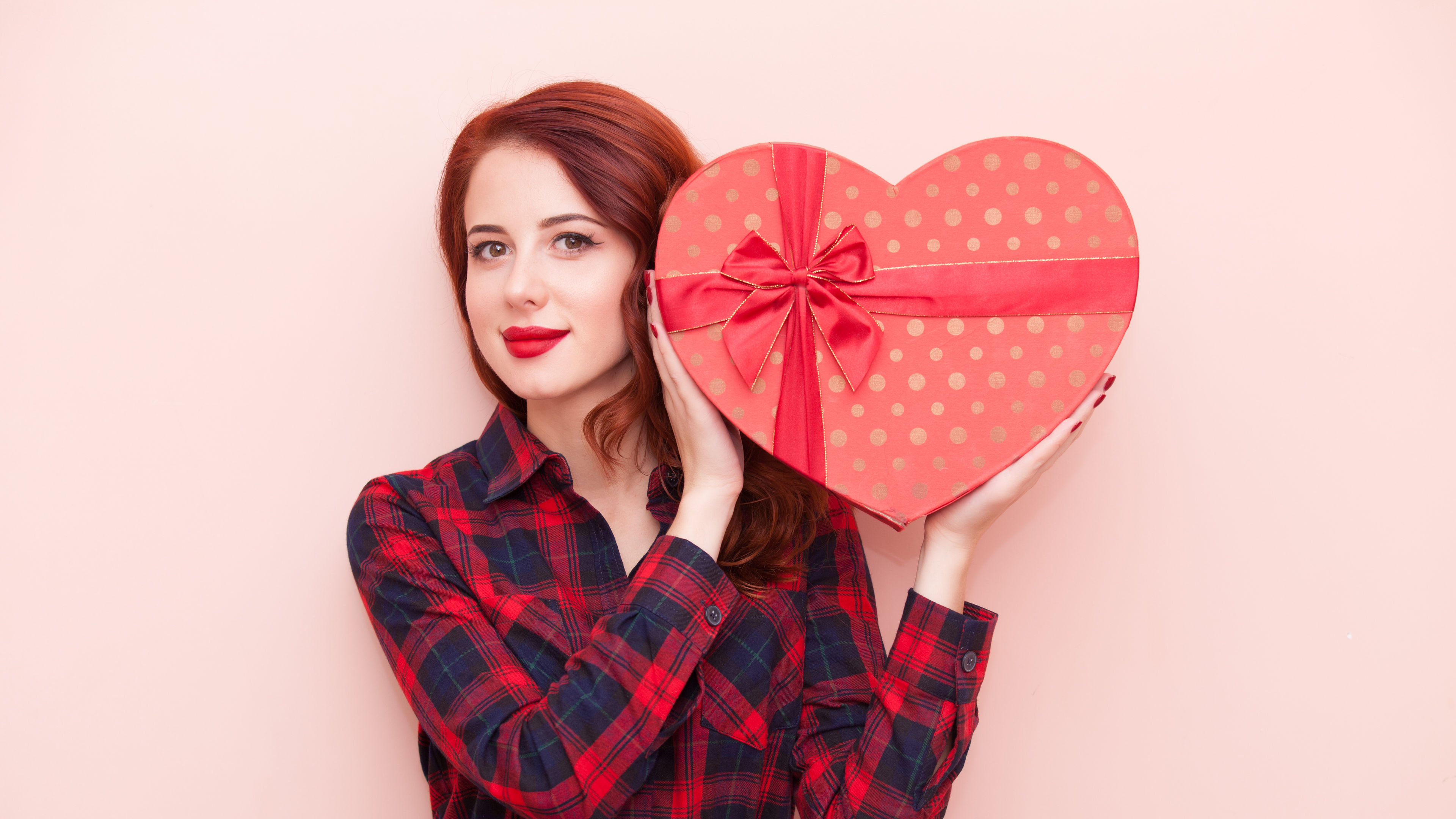 Girl holding a beautifully wrapped gift box with a cheerful expression. 