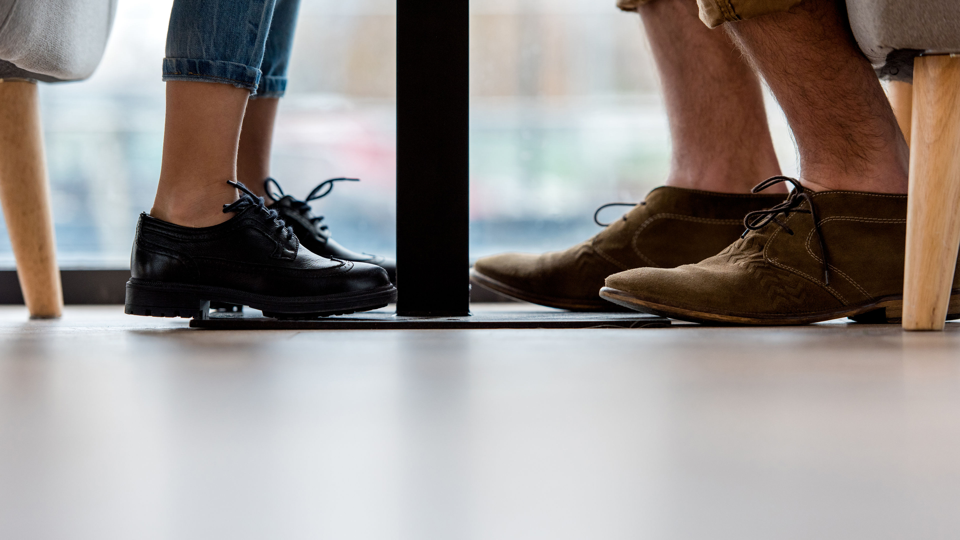 Legs of two people with black shoes  